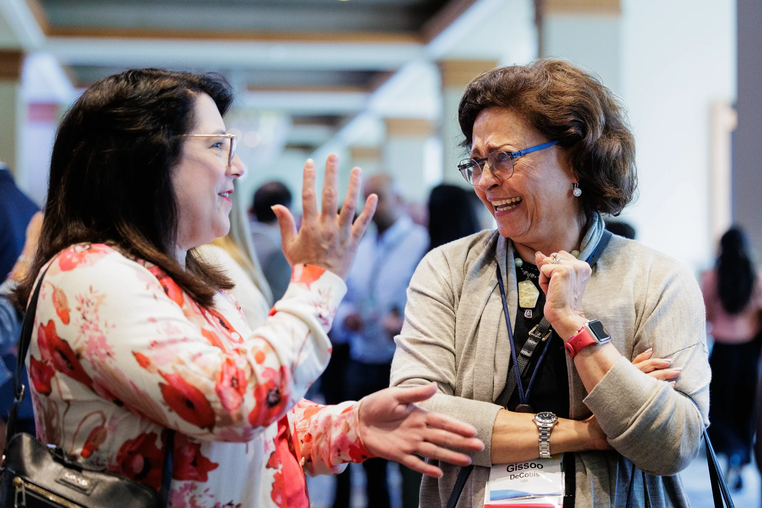 Two attendees share a laugh during conversation at Chicago industry conference