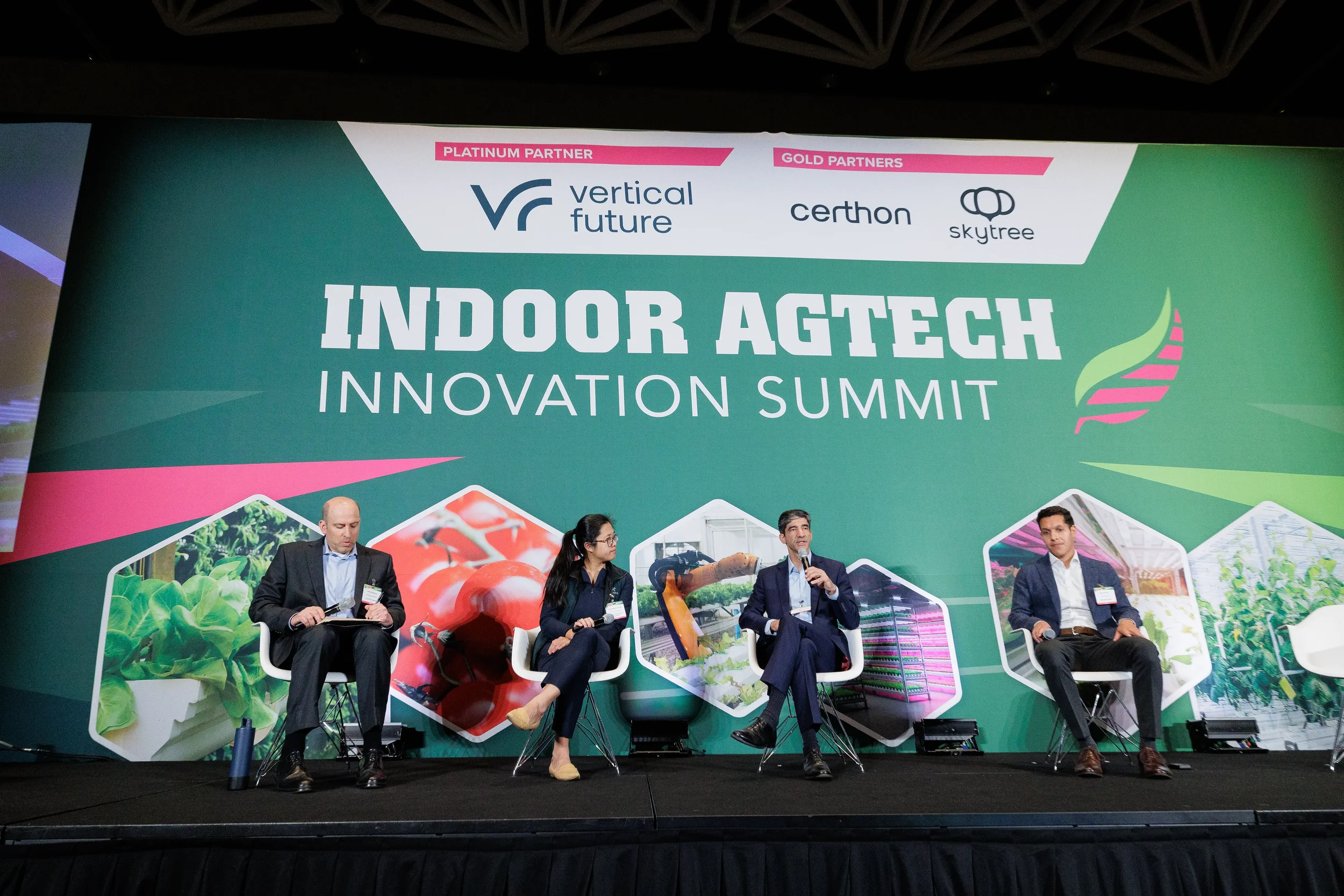 Four panelists discuss on stage in front of branded backdrop at Orlando industry summit