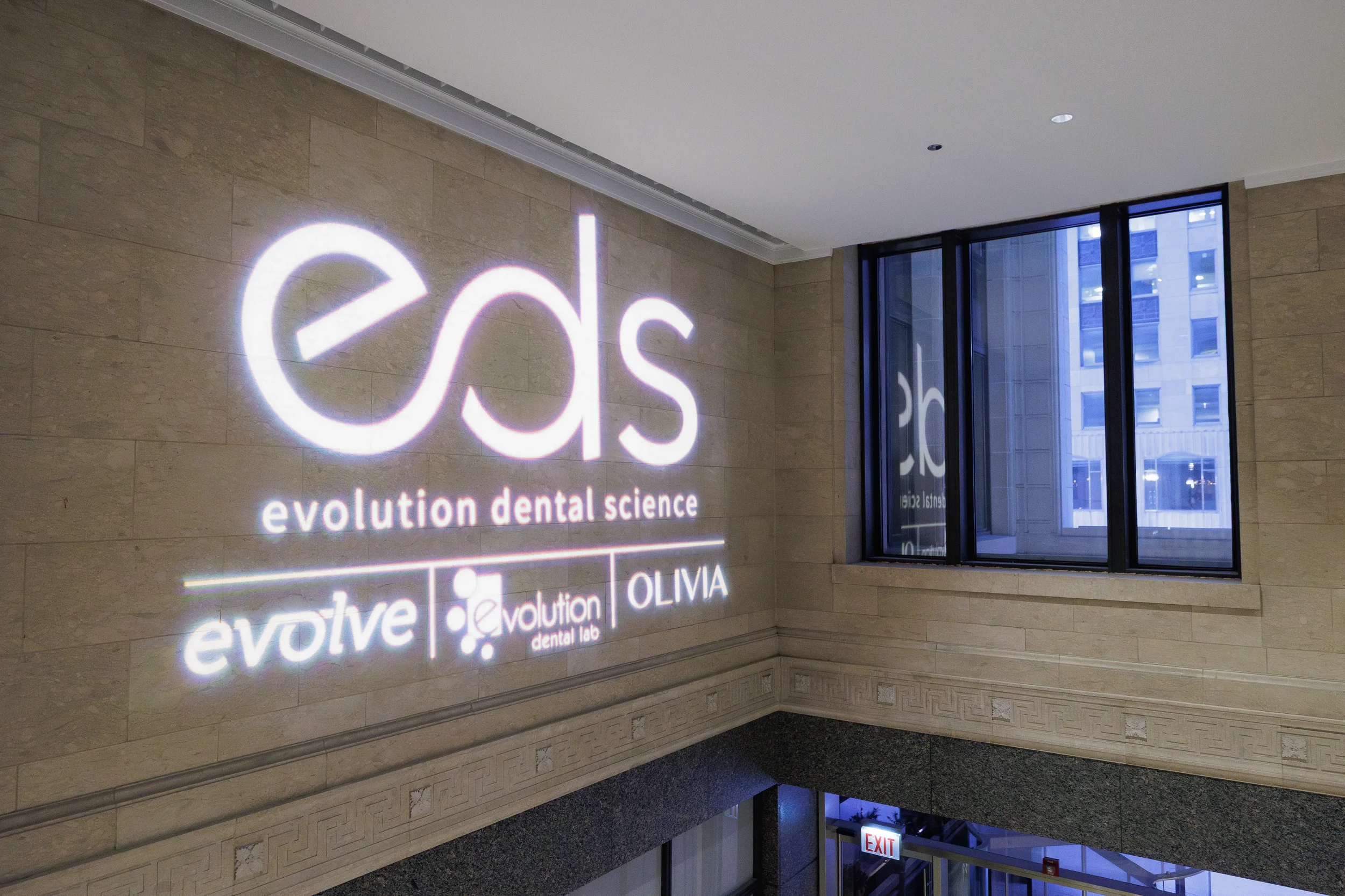 Branded logo projected onto stone wall at Chicago corporate event venue at night