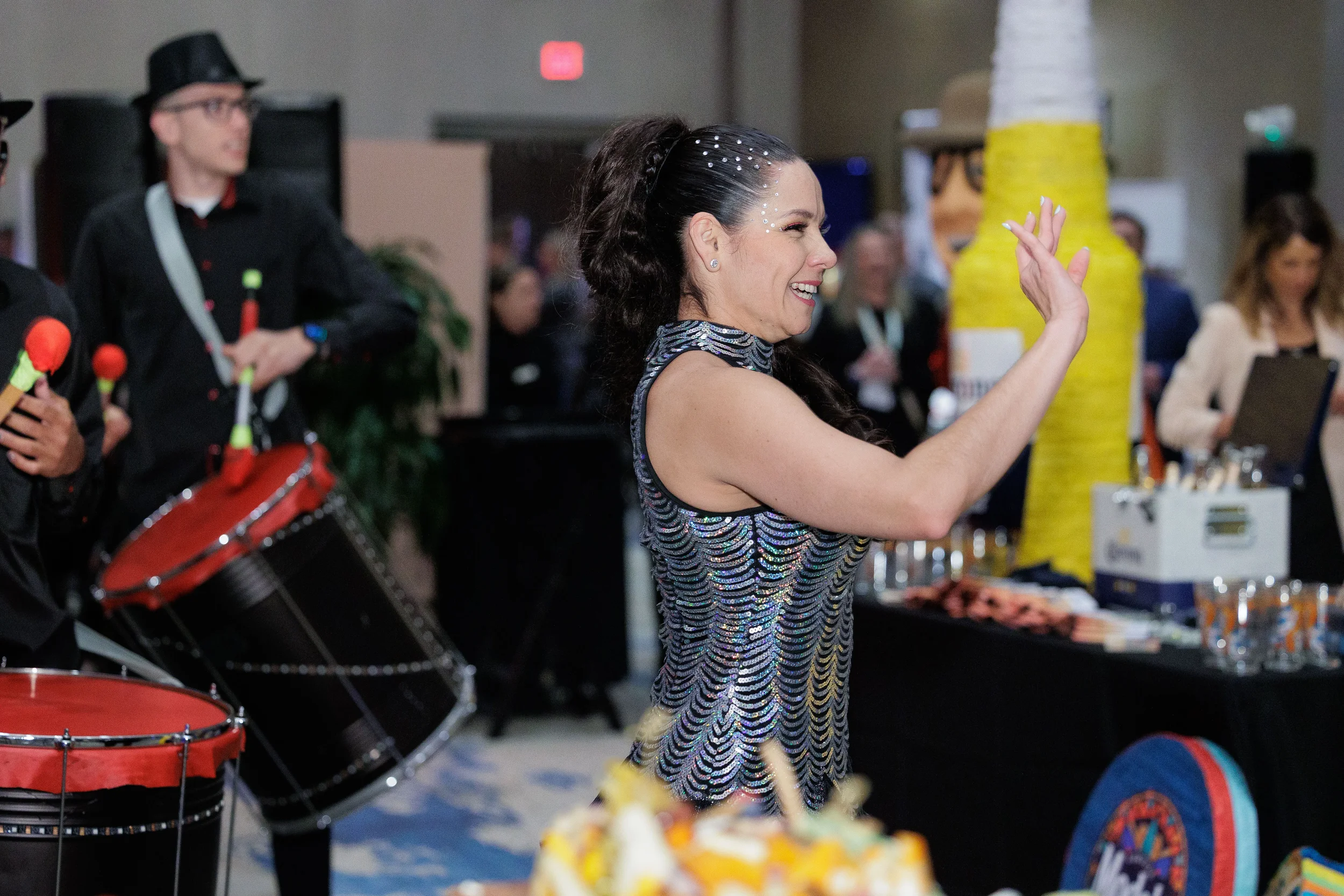 Sequin-dressed performer dances alongside live drummer on Orlando corporate conference expo floor