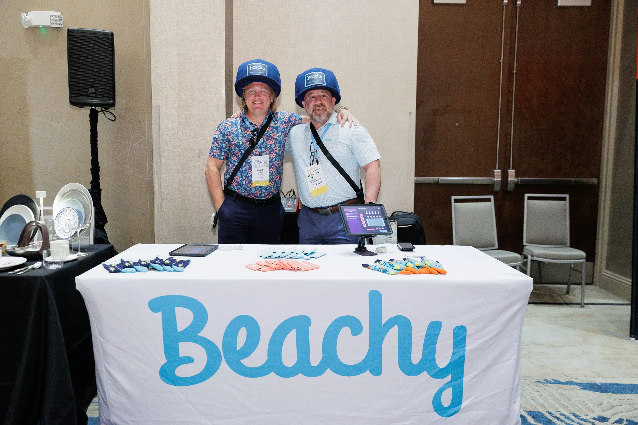Two attendees wearing branded helmets pose at exhibitor booth during Chicago corporate event expo floor