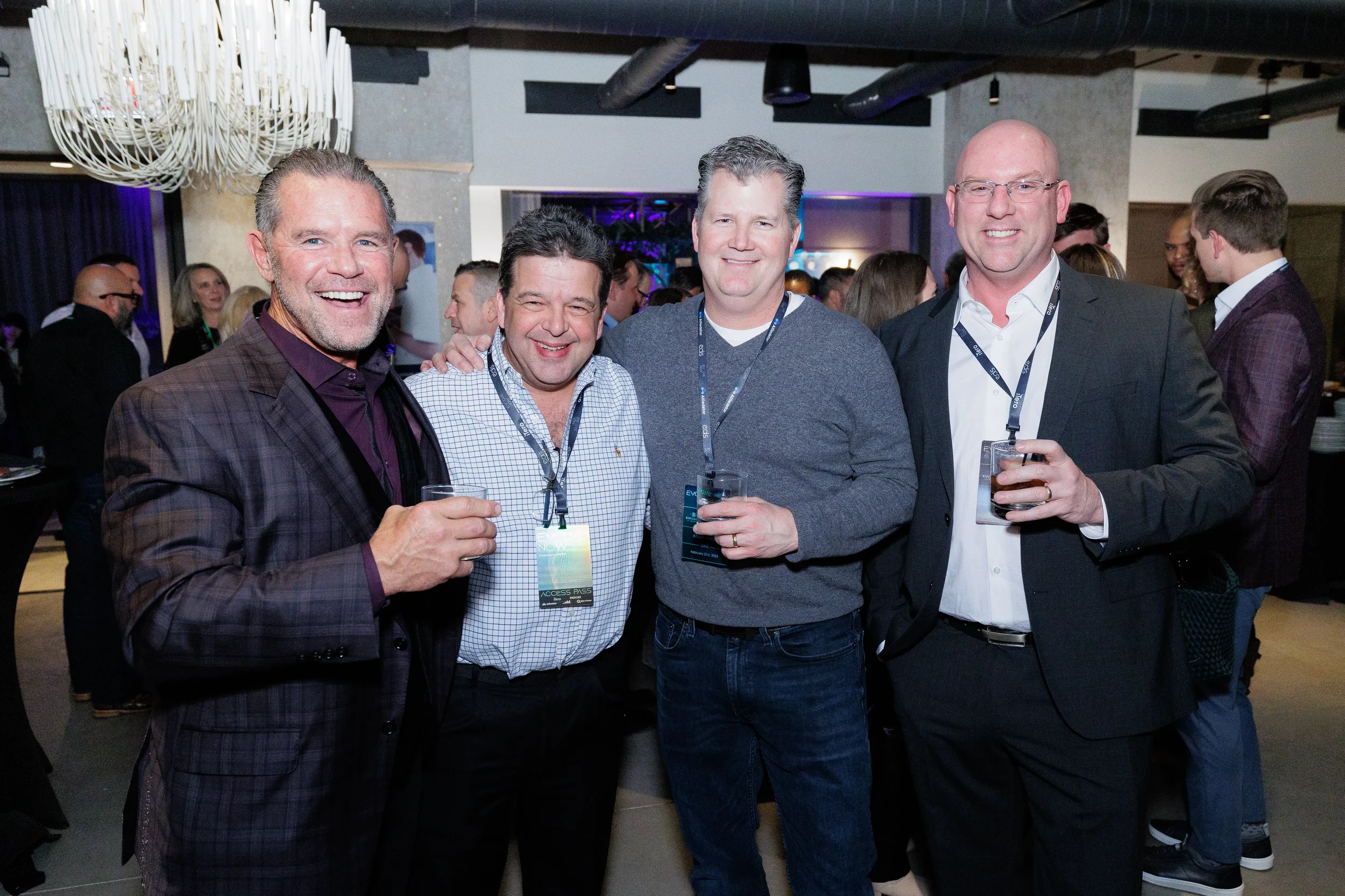 Four attendees smile and pose together with drinks during networking reception at Chicago corporate event
