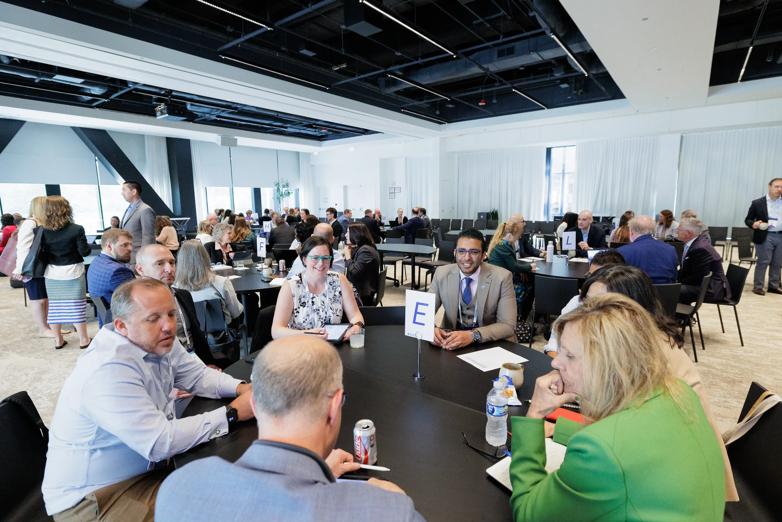 Attendees engage in roundtable discussion while seated at Chicago corporate conference session