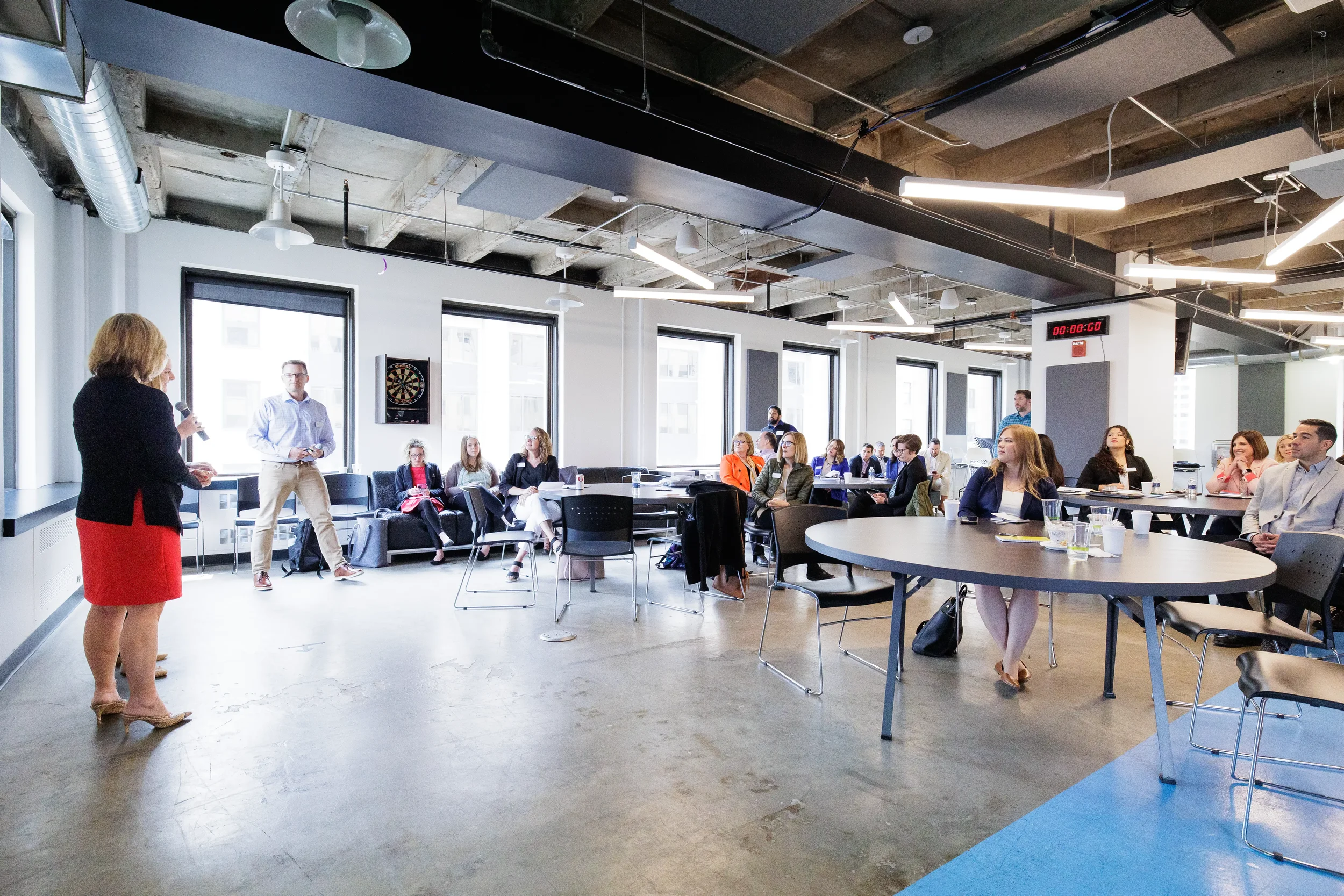 Female speaker with microphone addresses full room of seated attendees at Orlando conference