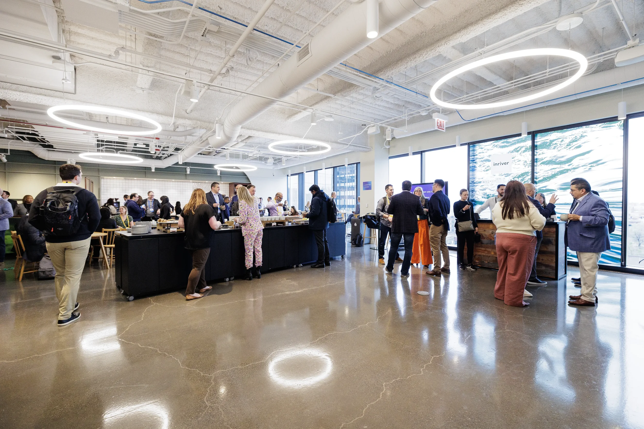 Attendees mingle around buffet and lounge beneath ring lights at Orlando corporate conference reception