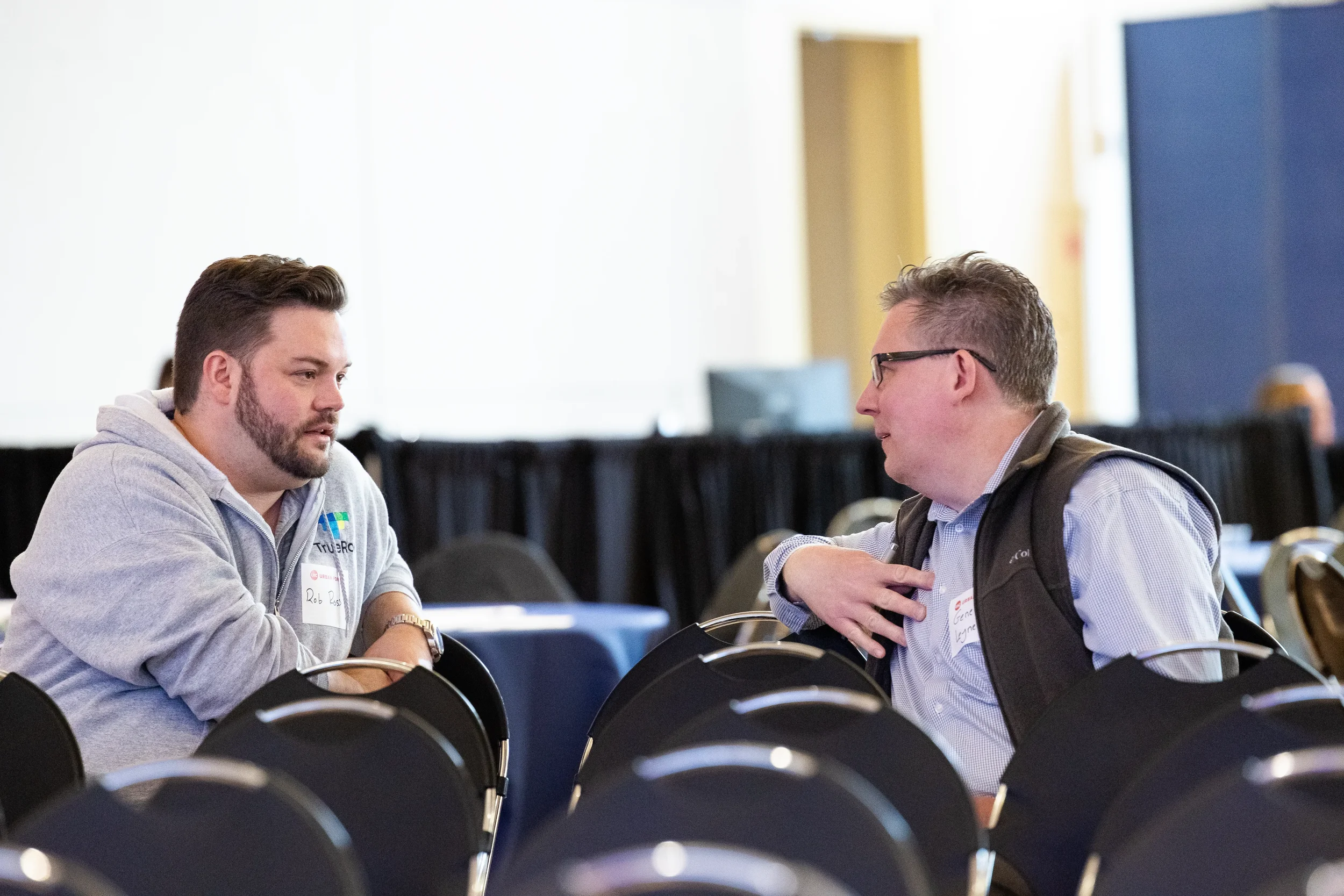Two attendees engage in conversation while seated during break at Orlando corporate conference