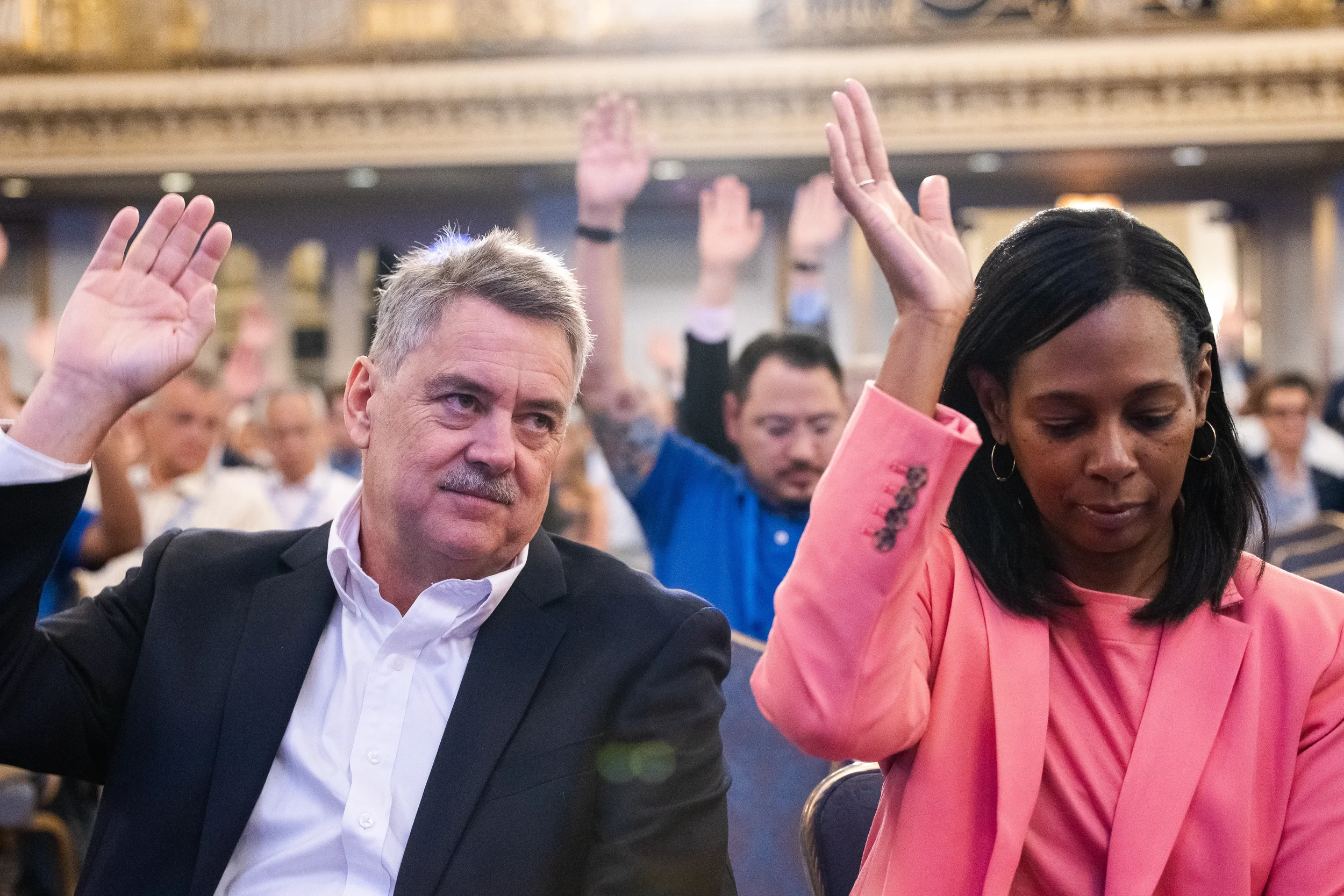 Conference attendees raise hands during interactive session at AACE International 2024 in Chicago