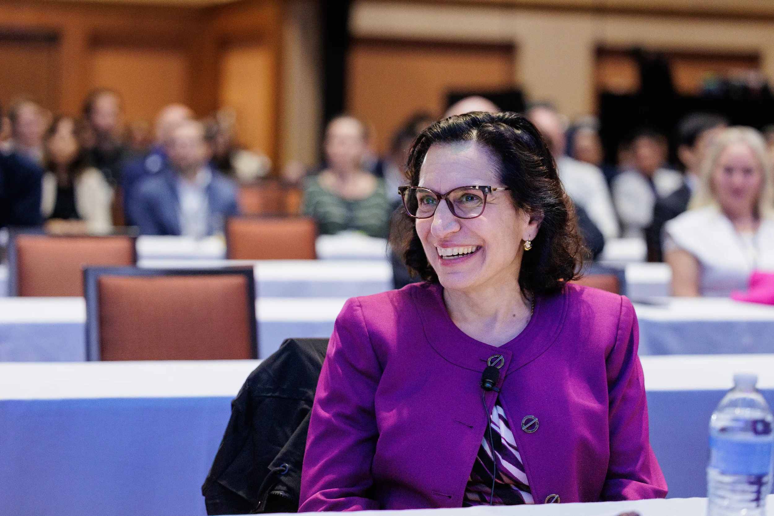 Attendee smiles while seated during conference session at Orlando industry event