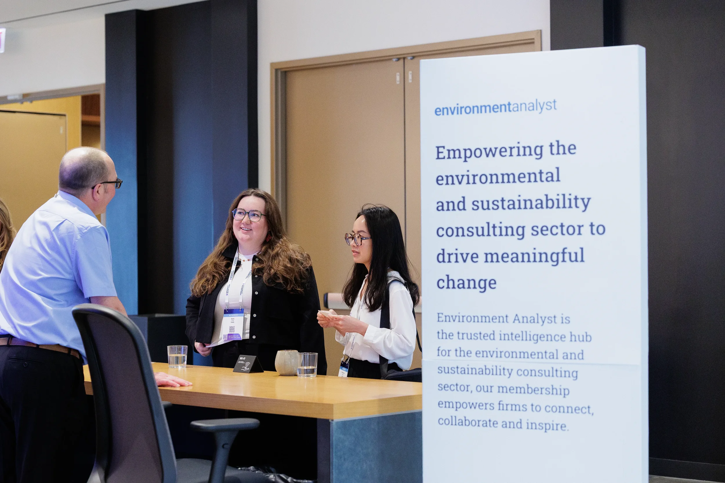 Attendees converse while standing at sponsor booth during Chicago industry conference