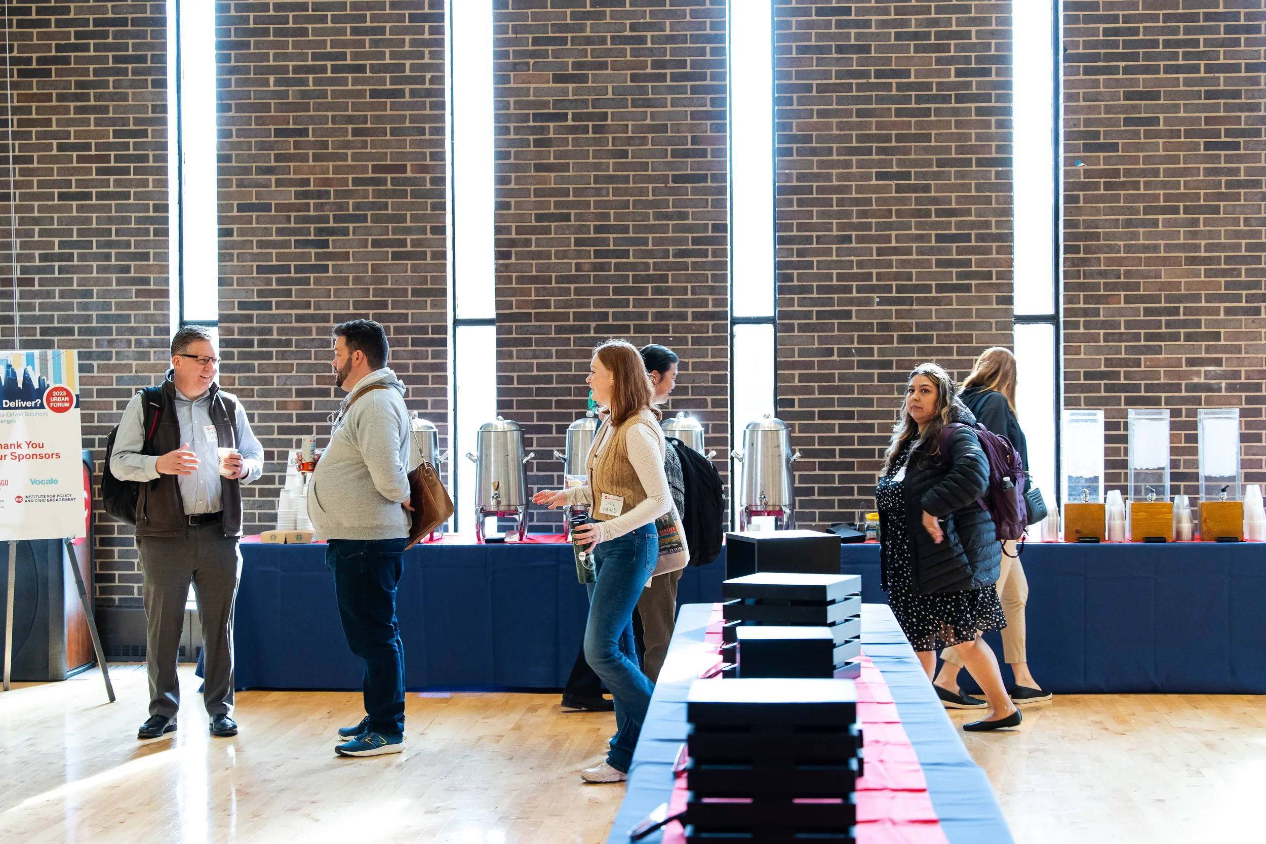 Conference attendees network near coffee station during registration at Chicago corporate event