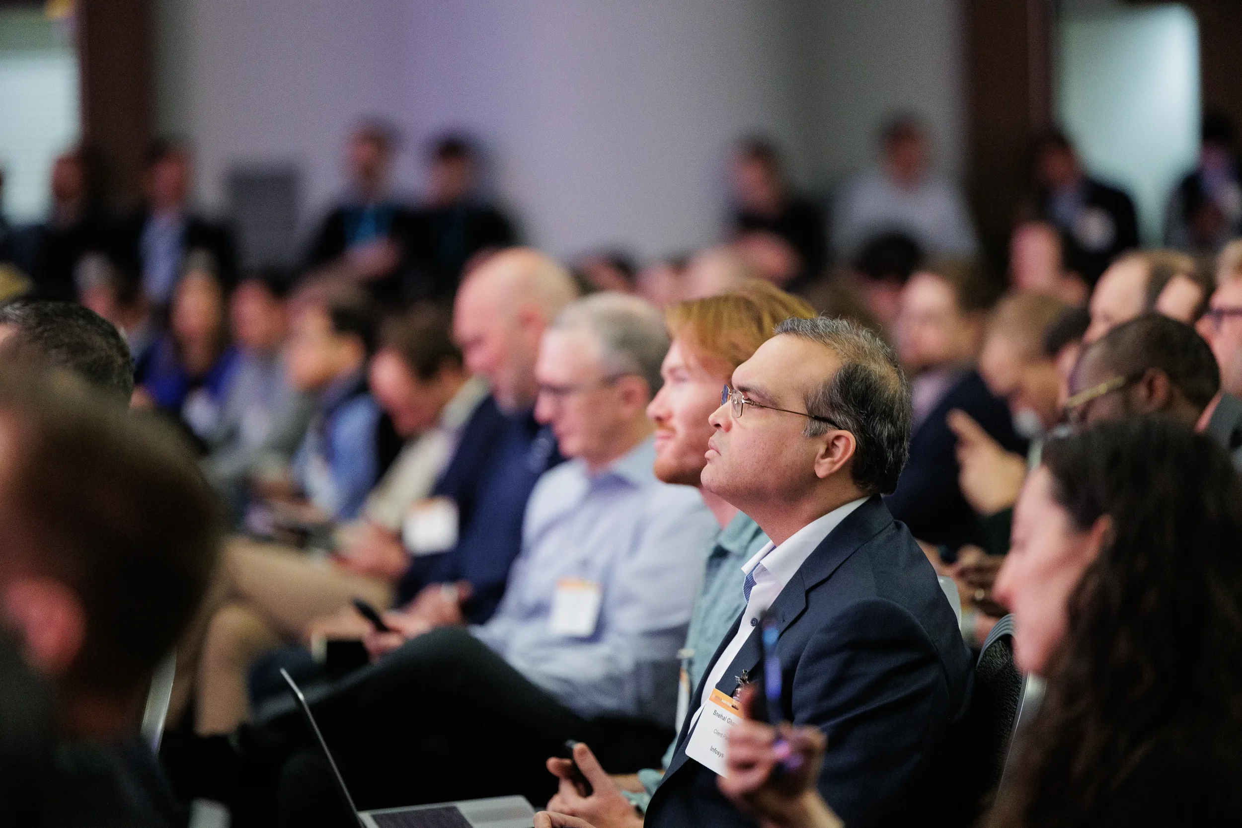 Attendees listen attentively from seated audience during session at Chicago industry conference