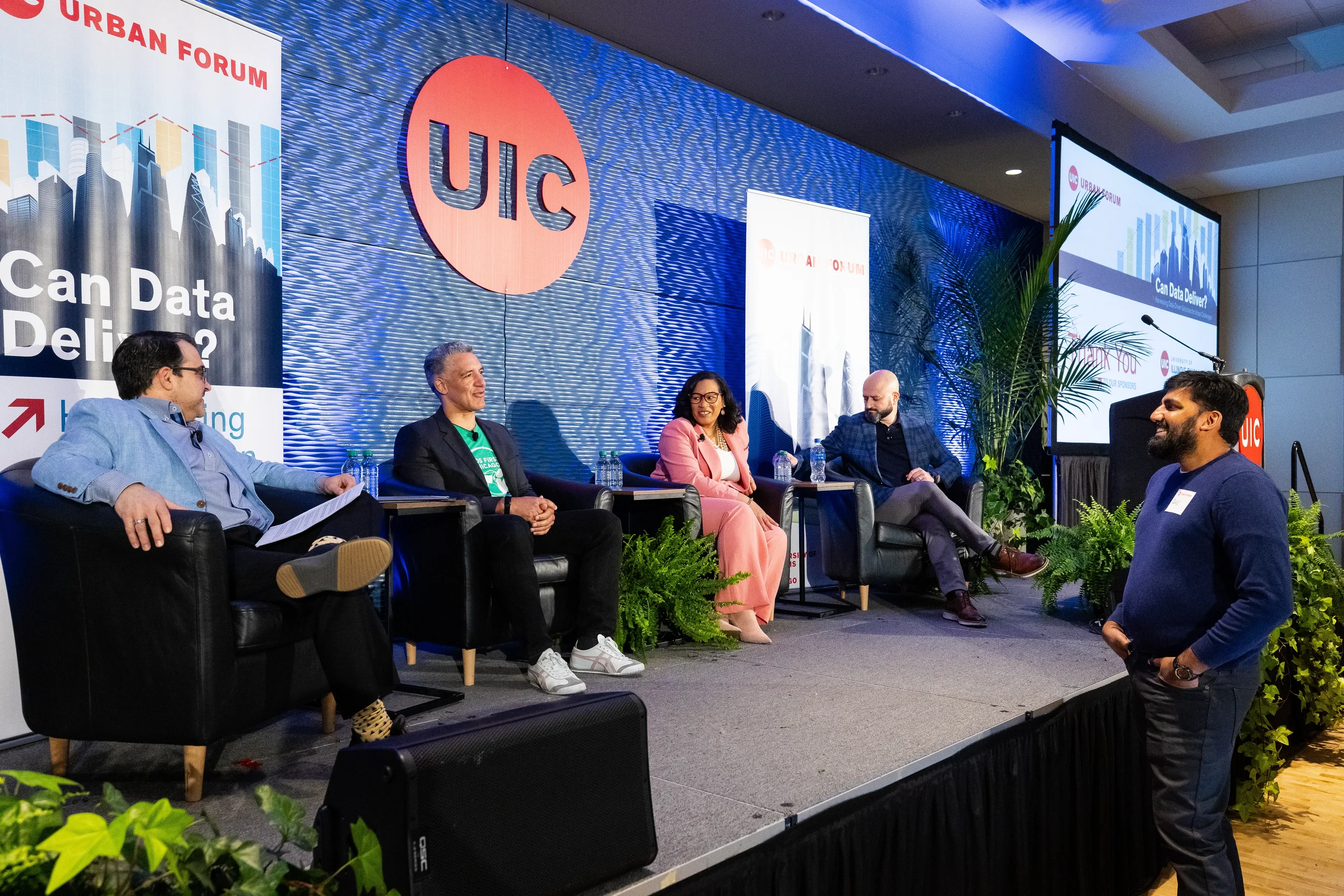 Five panelists on stage engage with audience member question at Chicago corporate conference