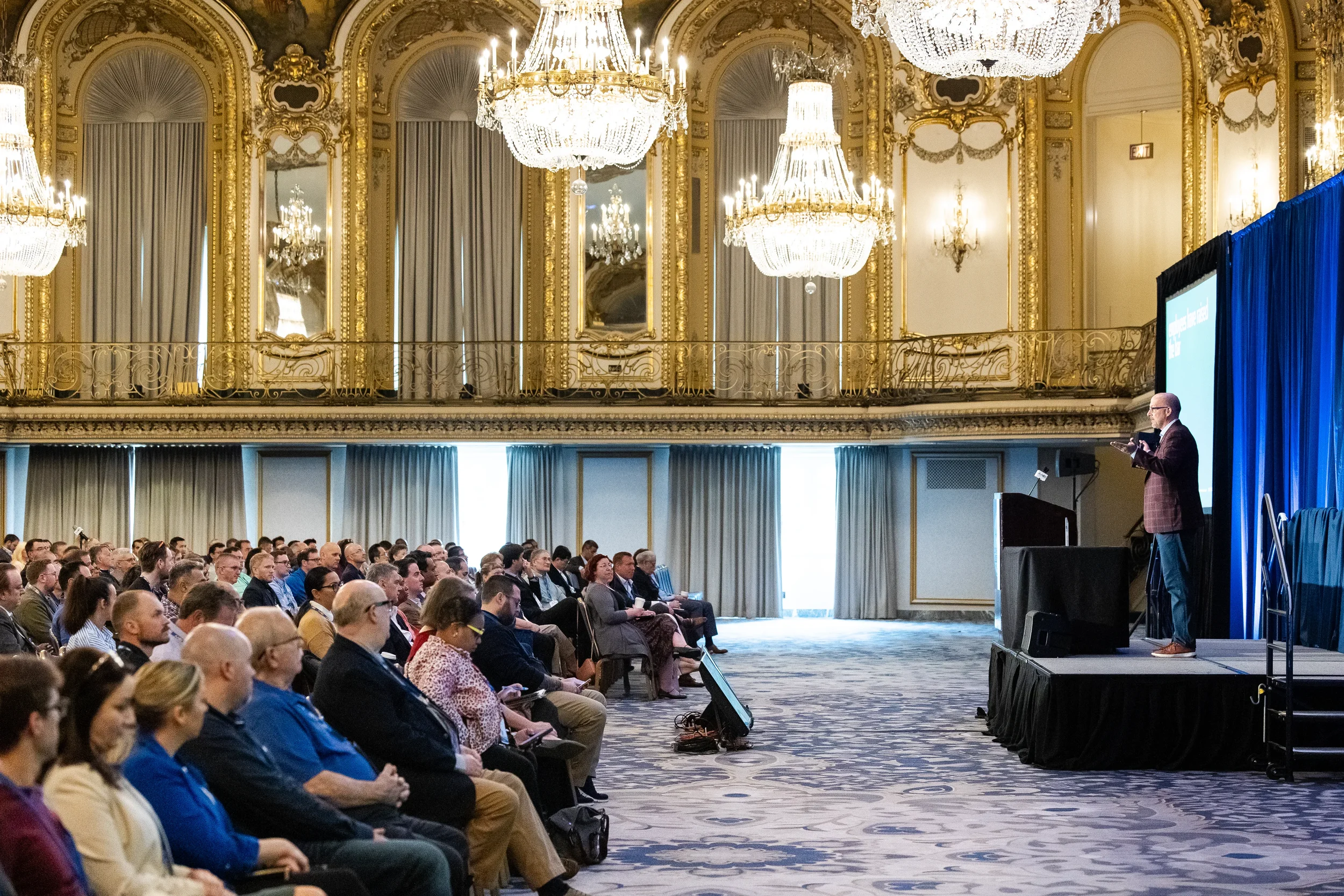 Keynote speaker addresses packed ballroom beneath crystal chandeliers at AACE International 2024 in Chicago
