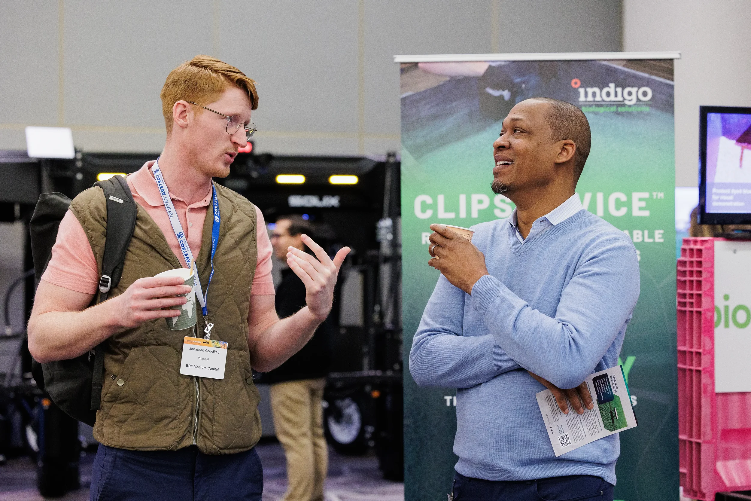 Attendees converse over coffee near exhibitor booth at Orlando trade show event