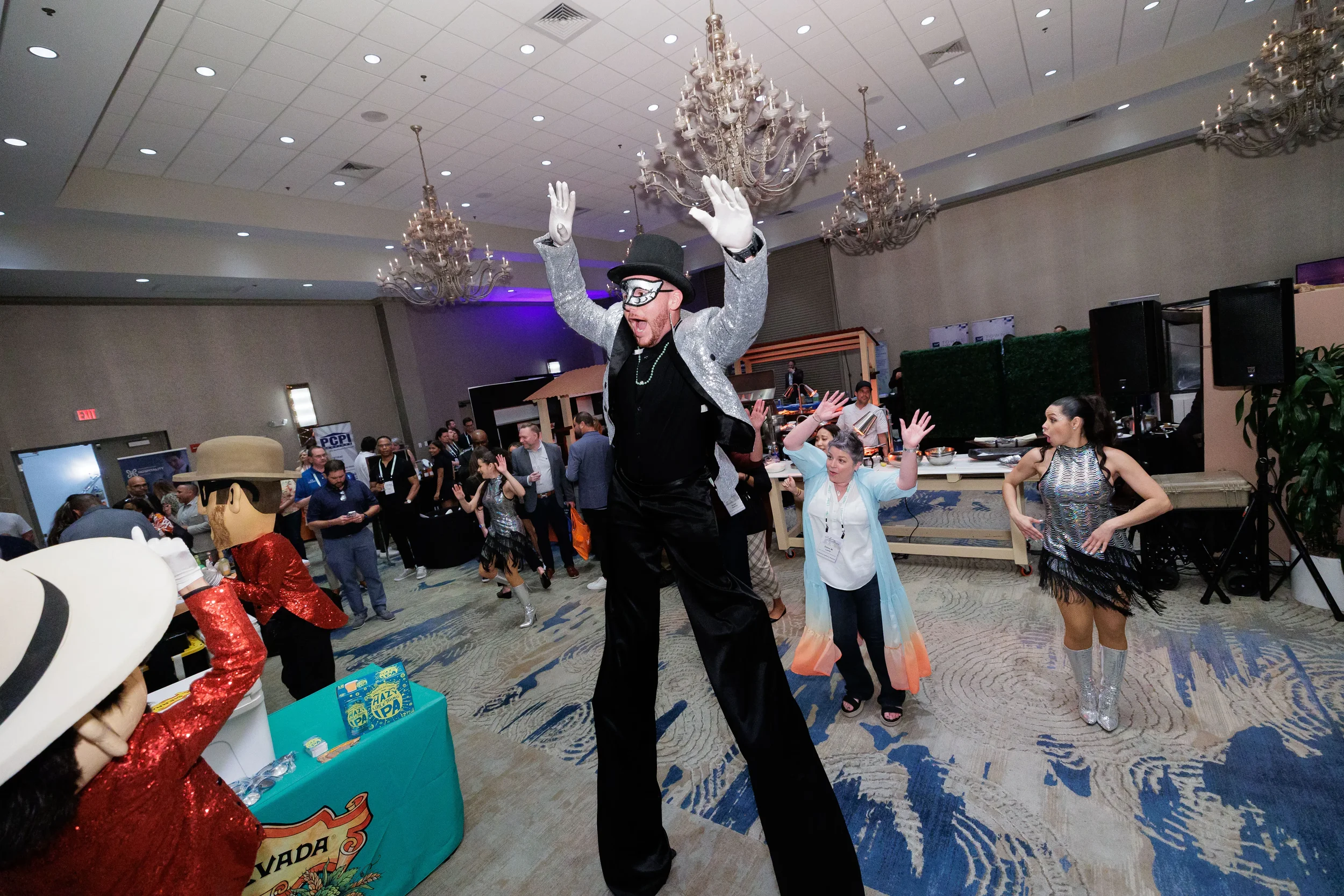 Masked stilt performer raises arms alongside dancers and mascots at Chicago corporate conference reception