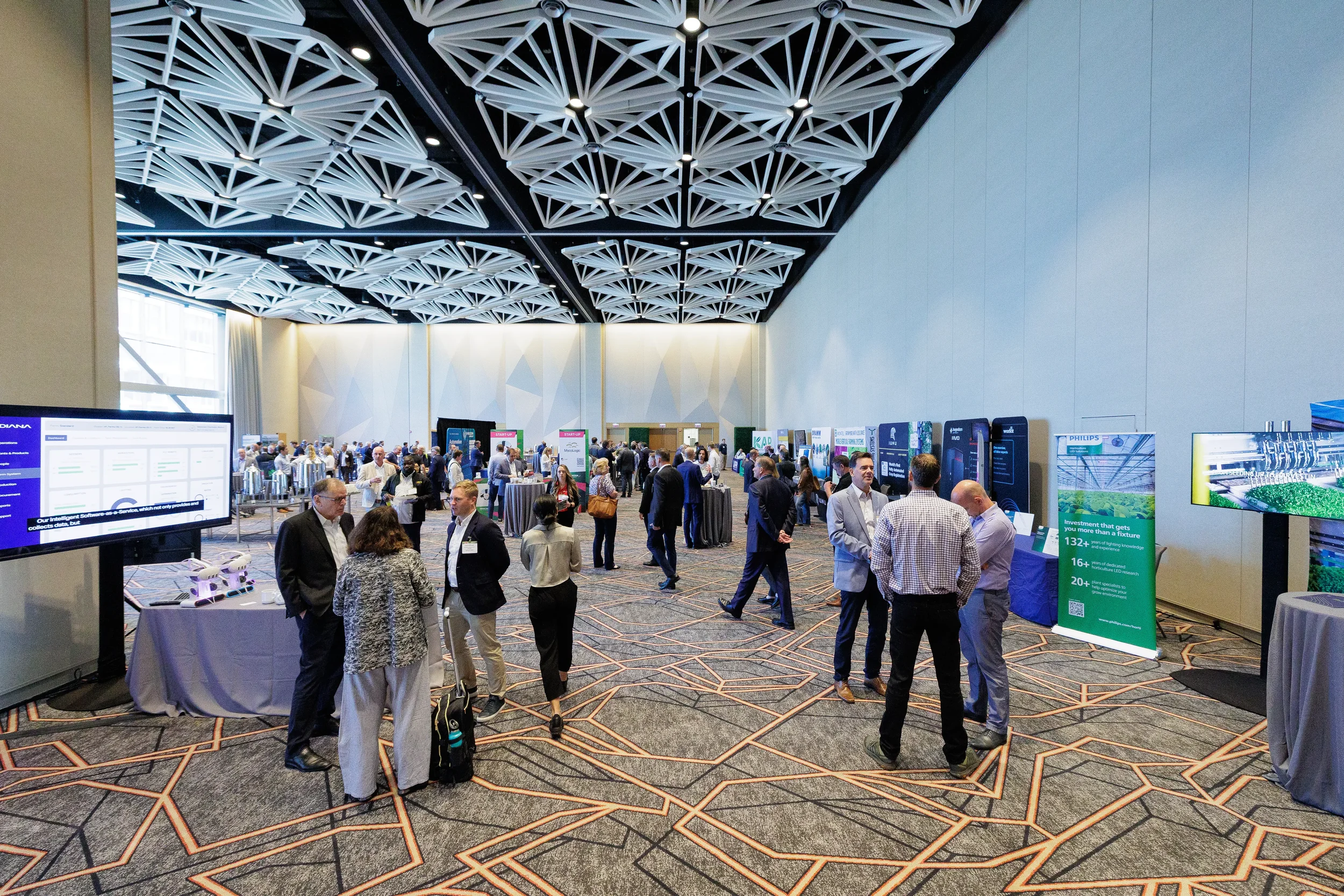 Attendees network and browse exhibitor booths across busy expo floor at Orlando industry conference