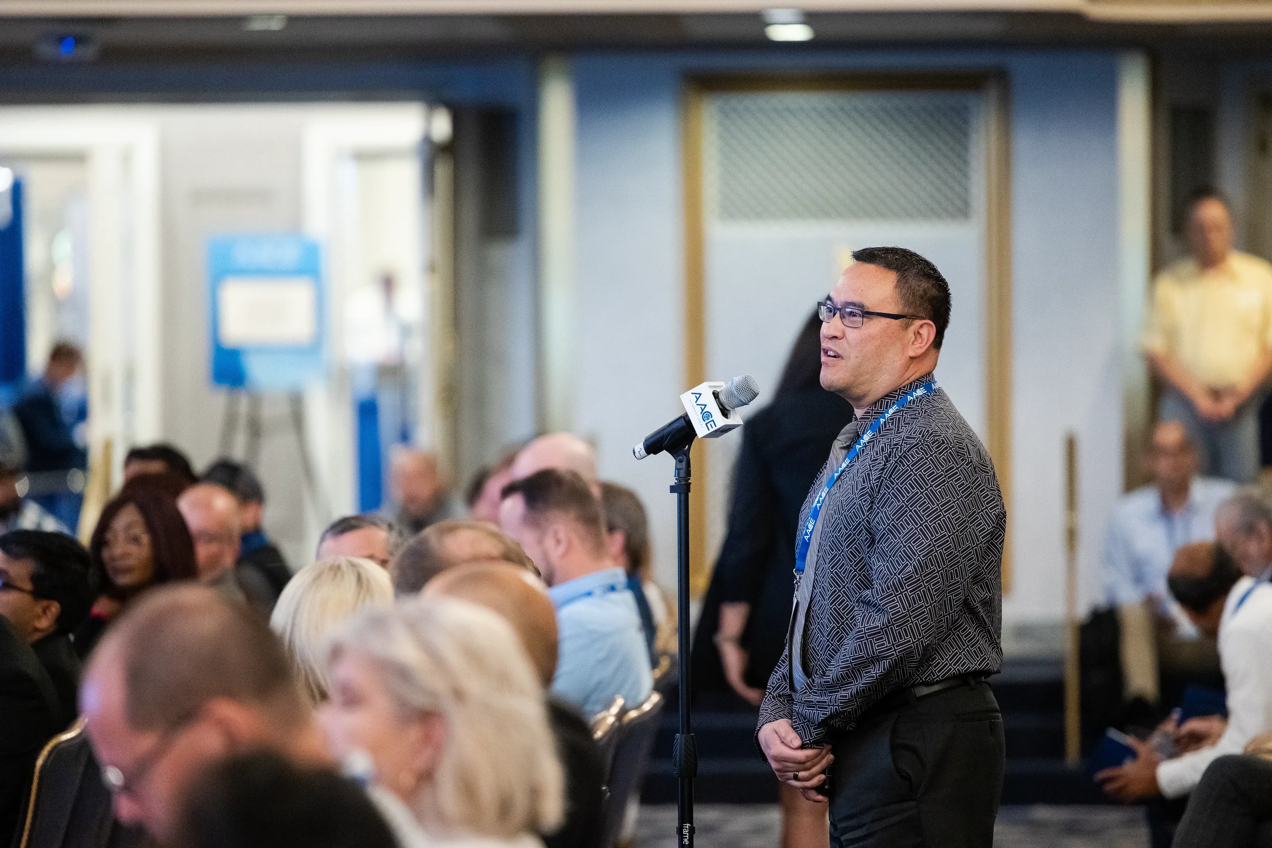 Attendee asks question at floor microphone during session at Orlando conference