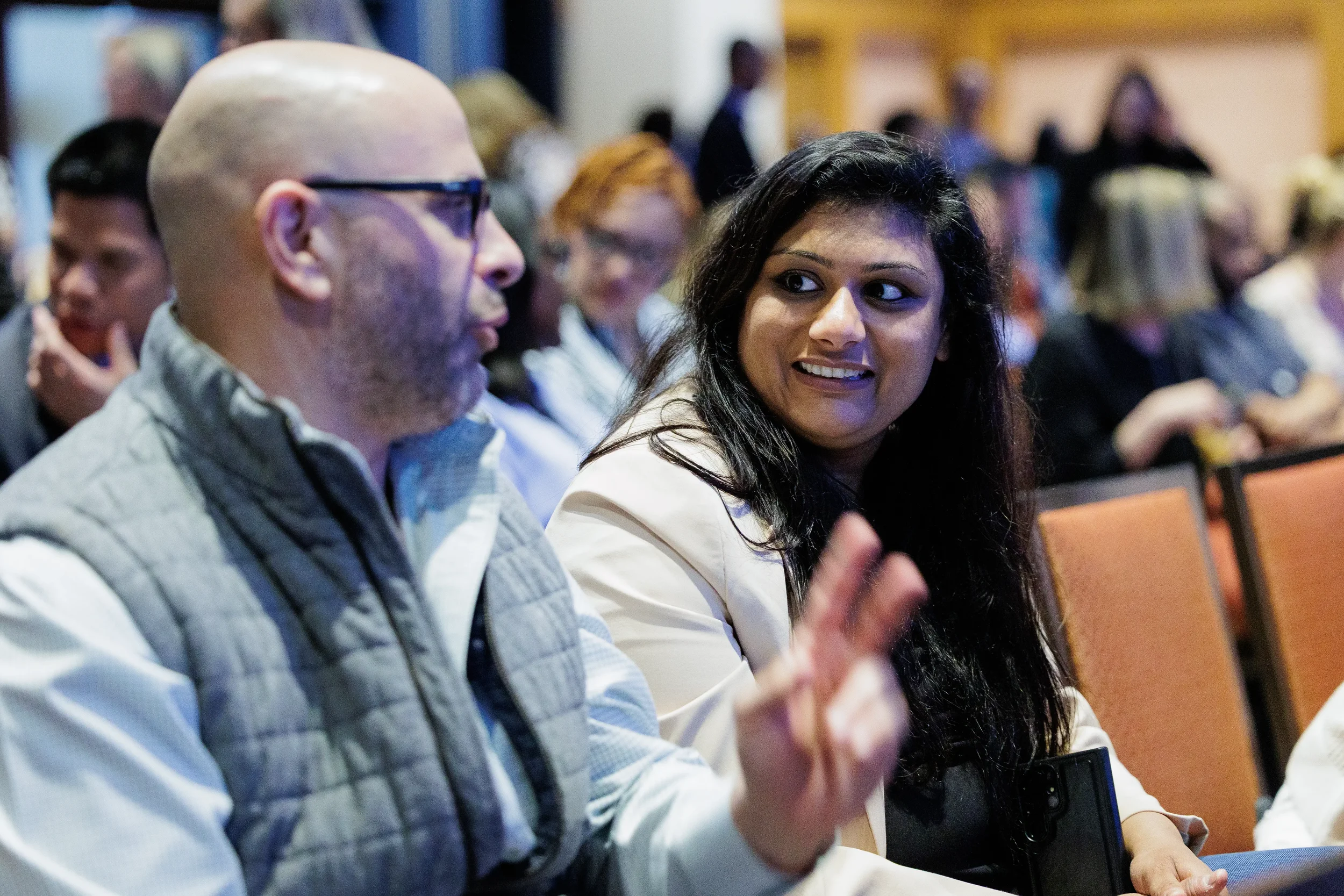 Attendee smiles while gesturing during conversation at Chicago corporate conference