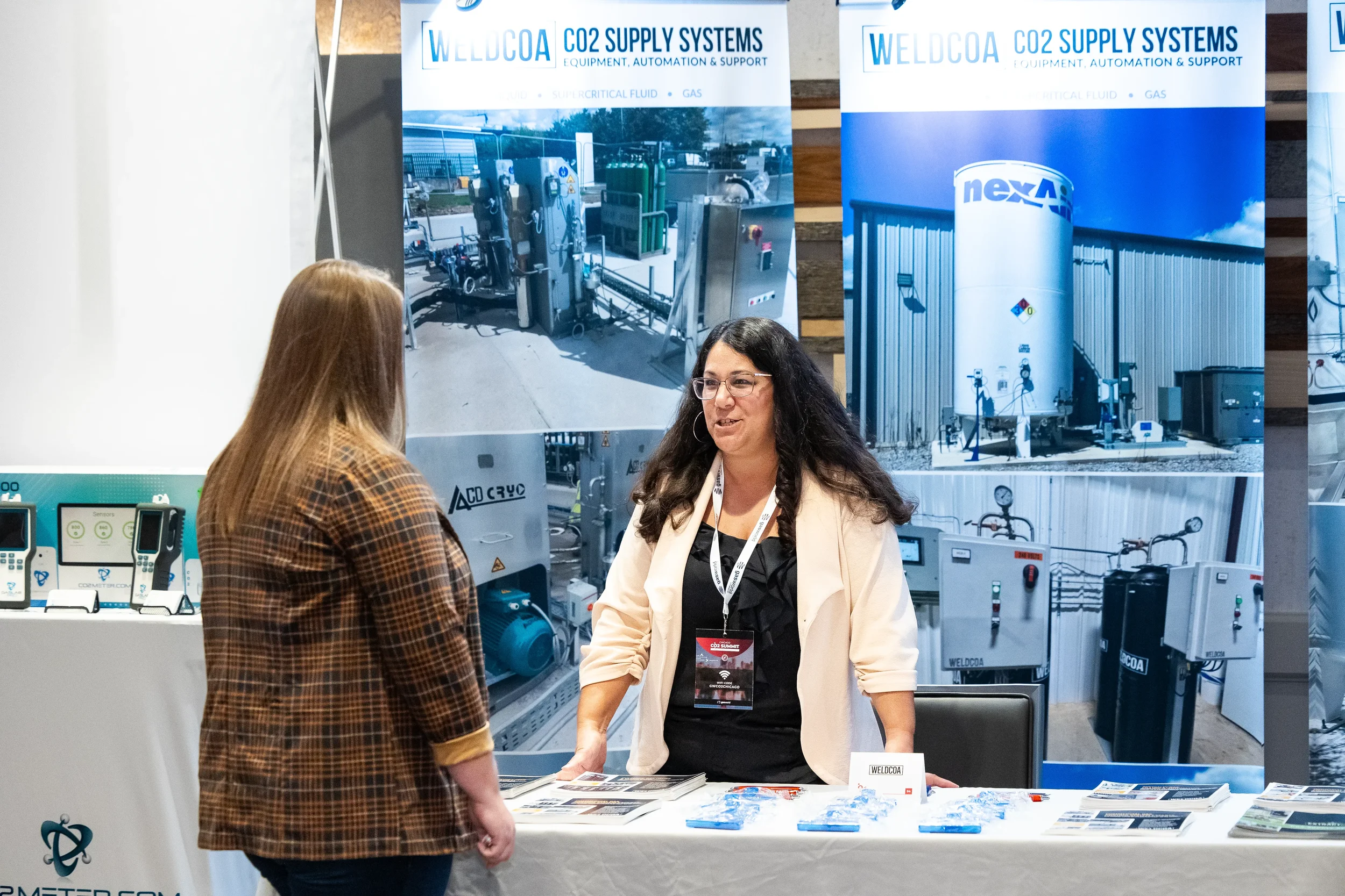 Exhibitor speaks with attendee at trade show booth during Orlando conference expo