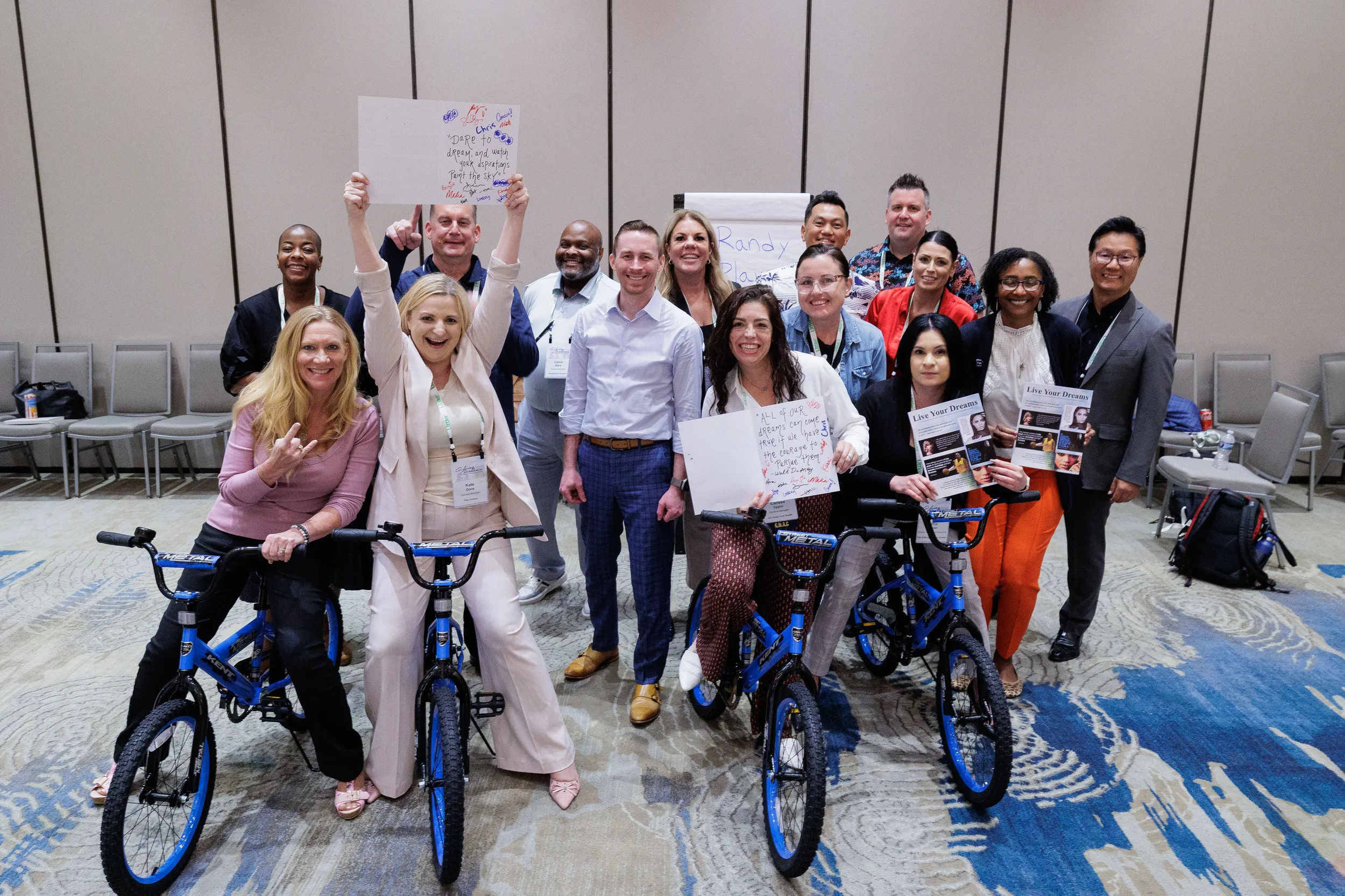 Group of attendees pose with blue bicycles after team building activity at Chicago corporate conference