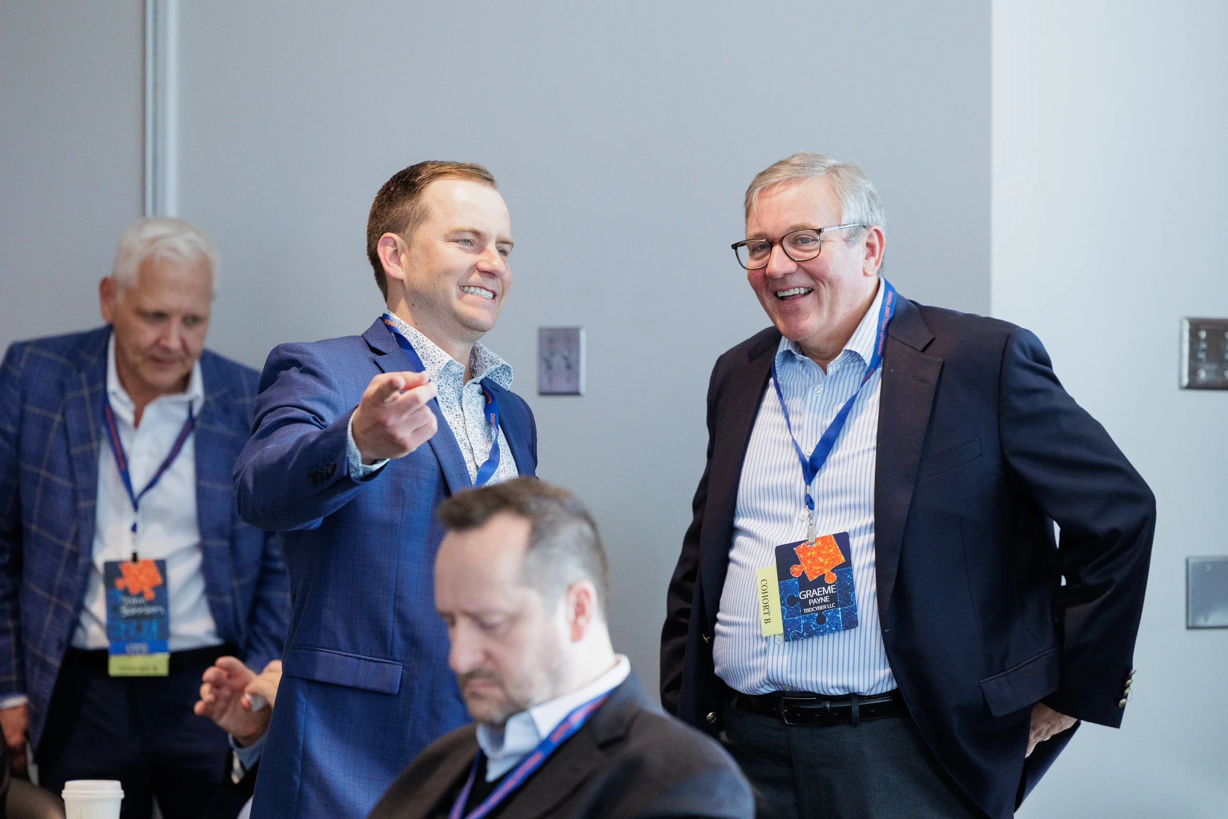 Two male attendees with lanyards laugh together during networking break at Chicago industry conference