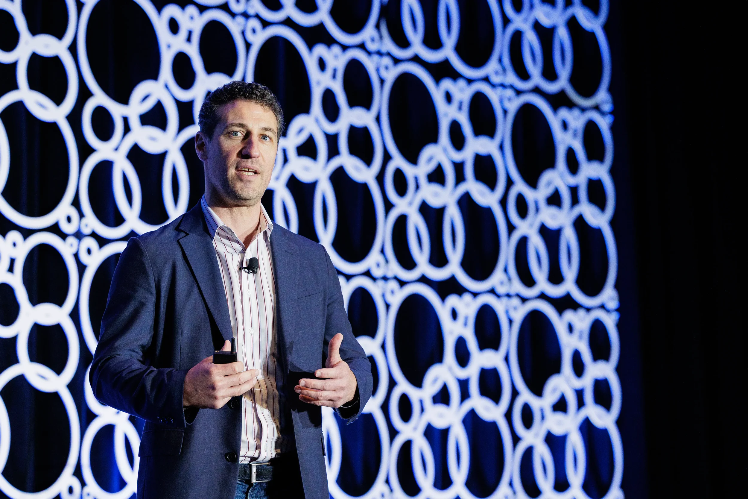 Speaker gestures while addressing audience on stage at Orlando corporate conference