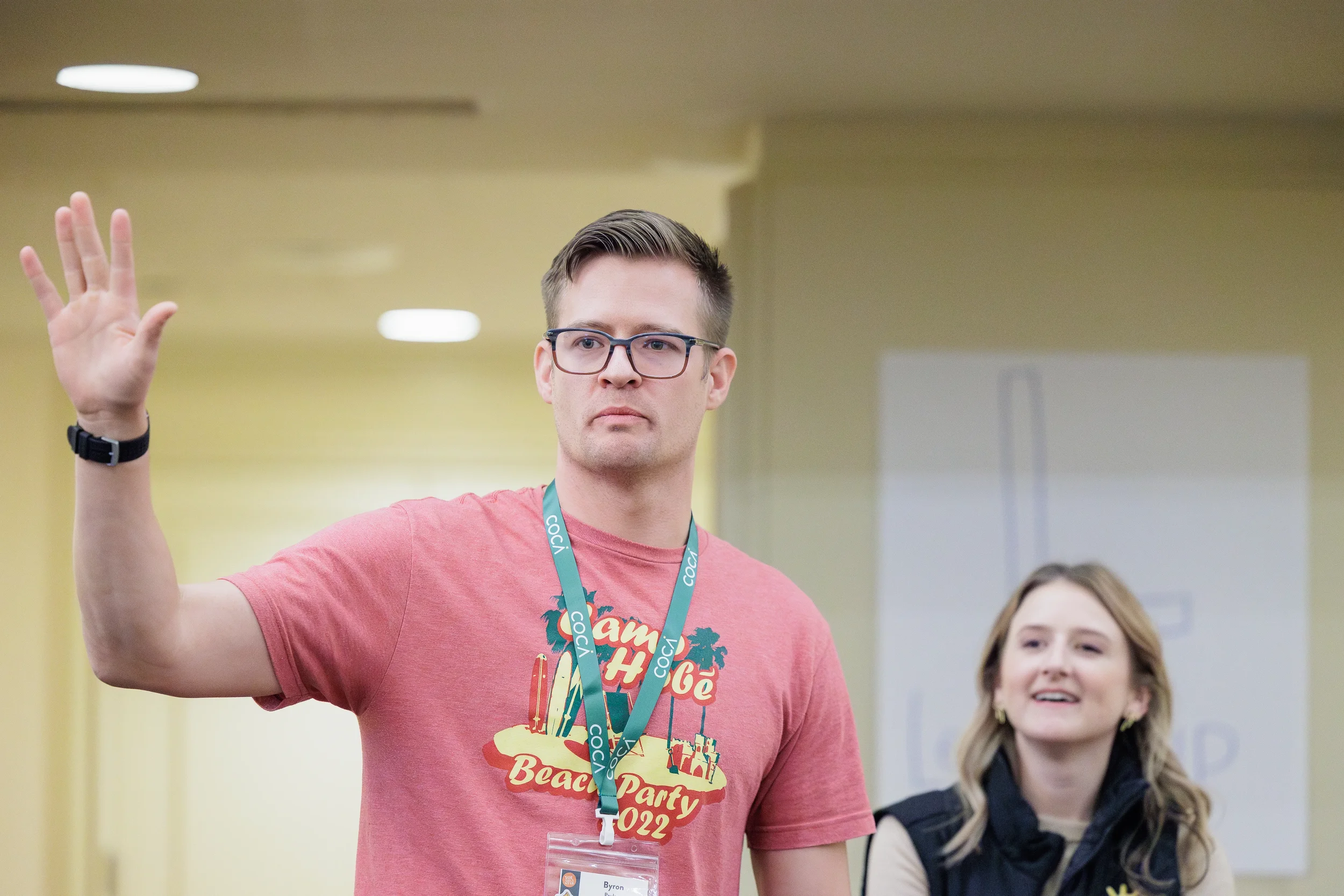 Attendee wearing conference lanyard raises hand to participate during breakout session at Orlando nonprofit conference