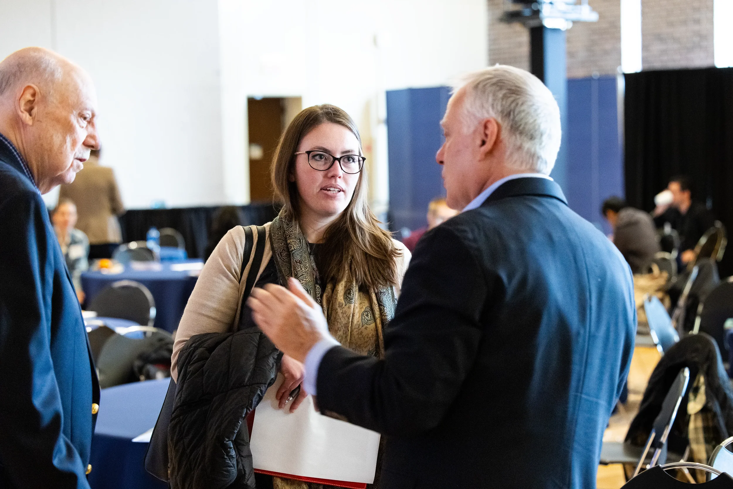 Three attendees engage in conversation during break at Chicago industry conference