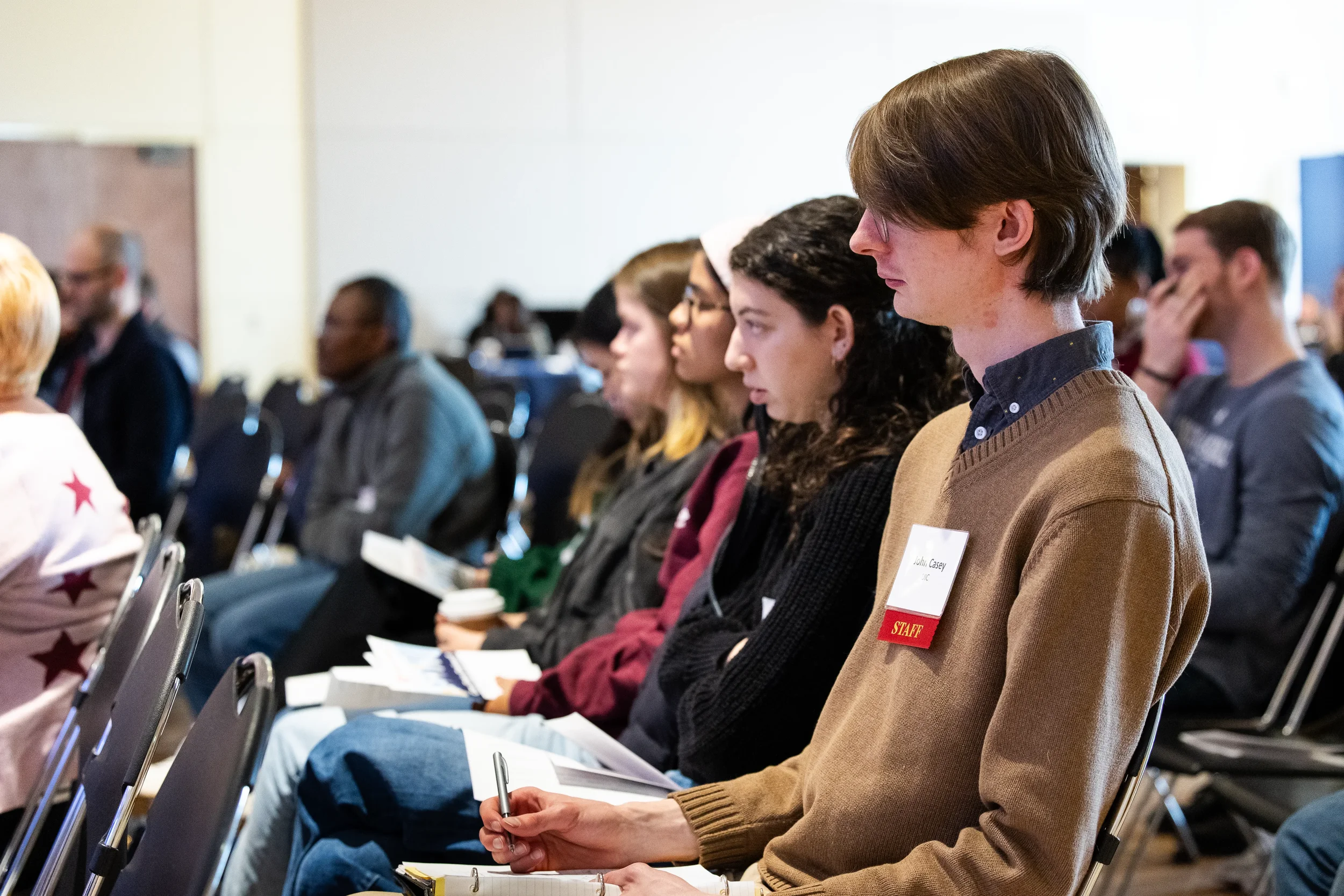 Attendees take notes while seated and listening during session at Chicago corporate conference