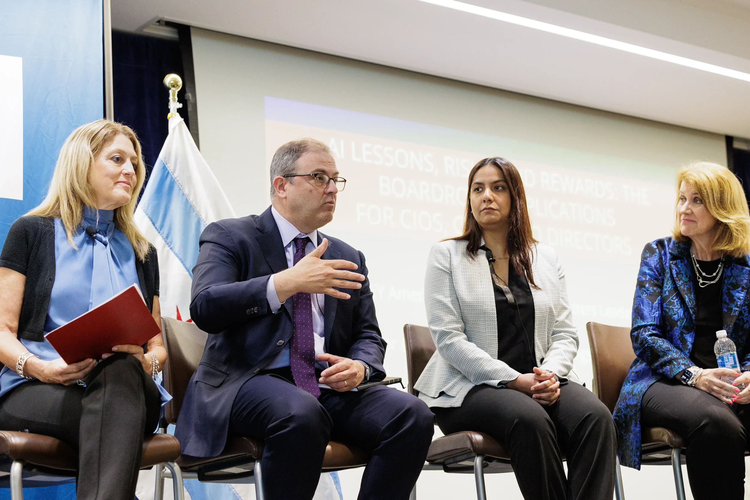 Four panelists seated in a row with male speaker gesturing during Chicago industry conference panel