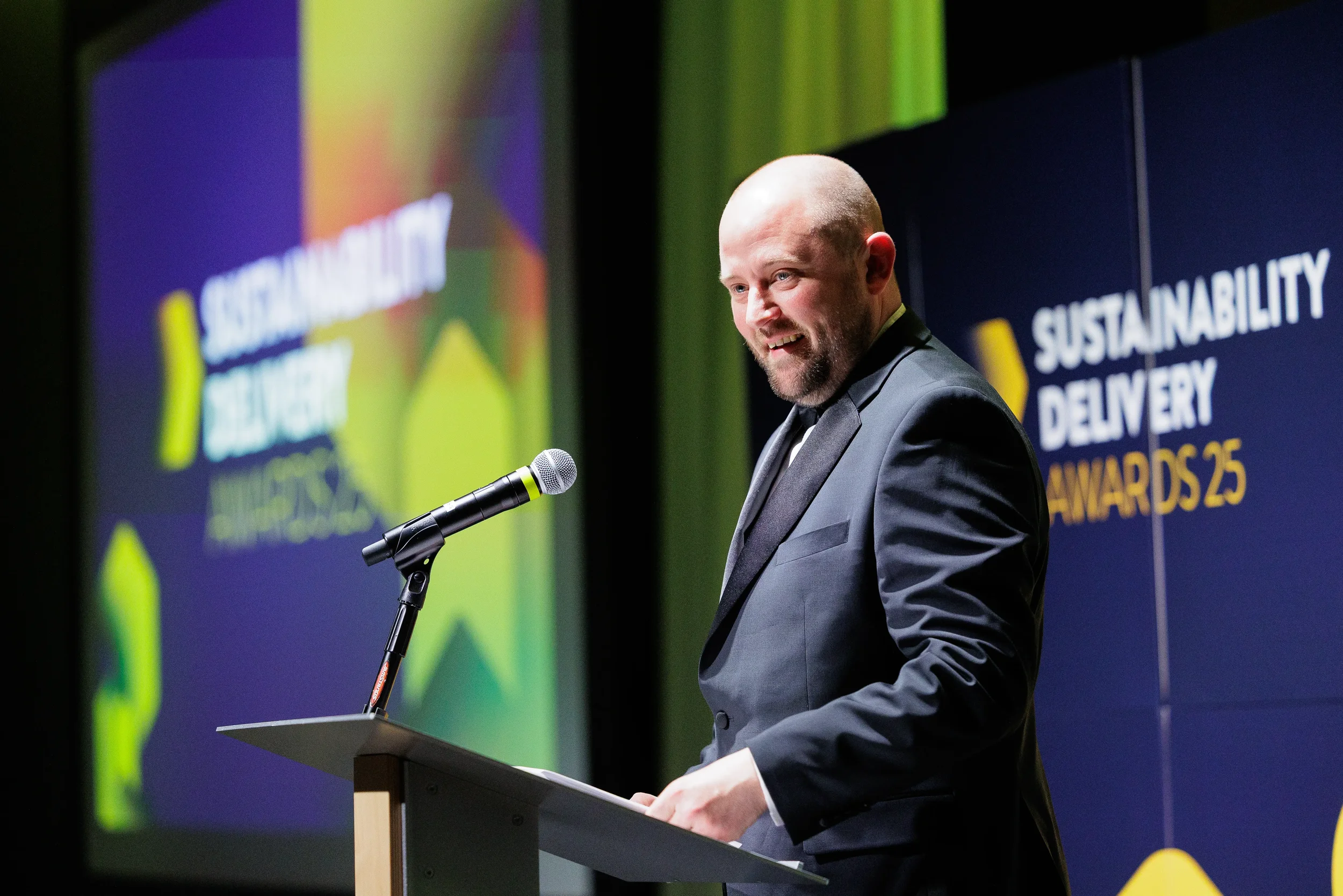 Host speaks from podium on stage during Chicago corporate event awards ceremony