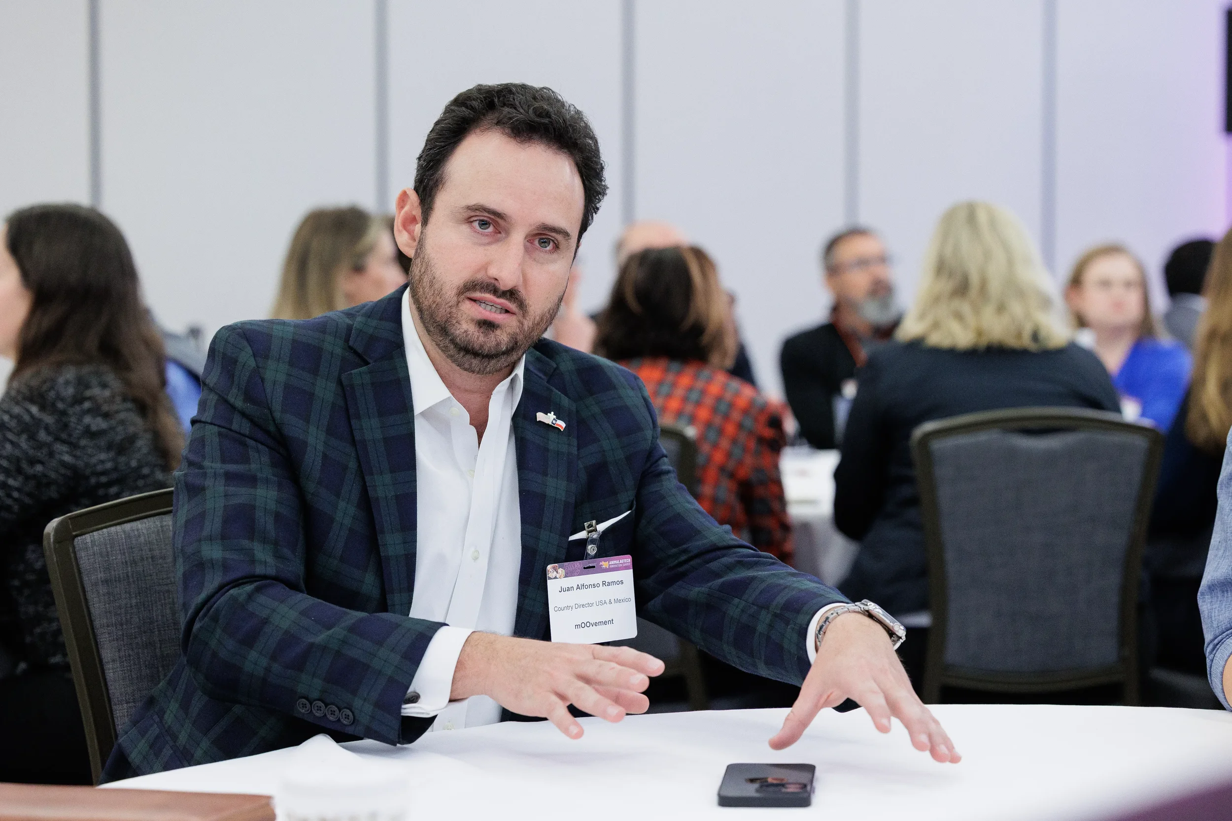 Attendee gestures while speaking at seated roundtable during Chicago corporate conference