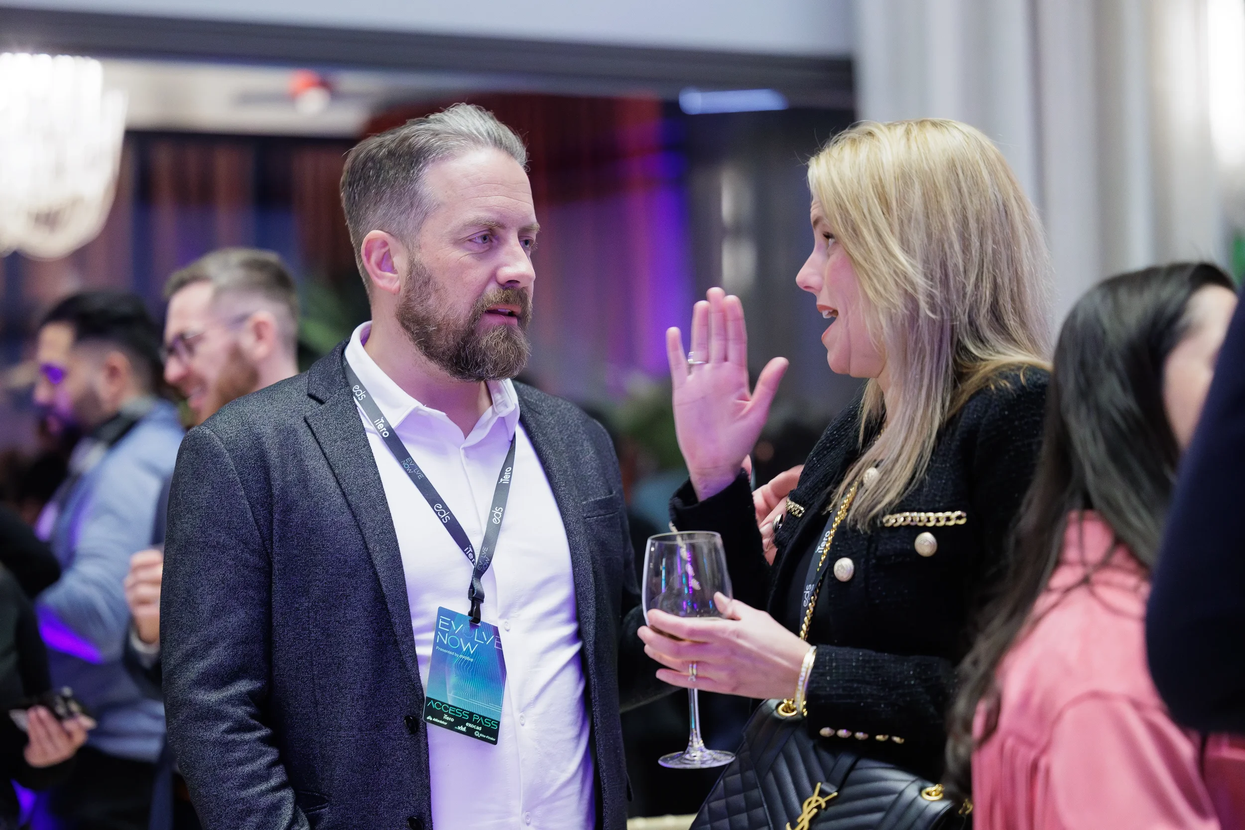 Two attendees engage in animated conversation with drinks at Orlando corporate event reception
