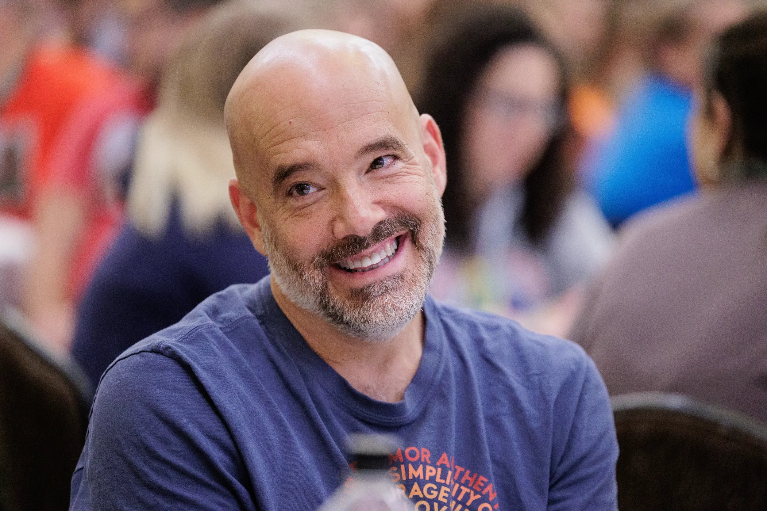 Smiling attendee seated among colorful crowd at Orlando nonprofit conference event