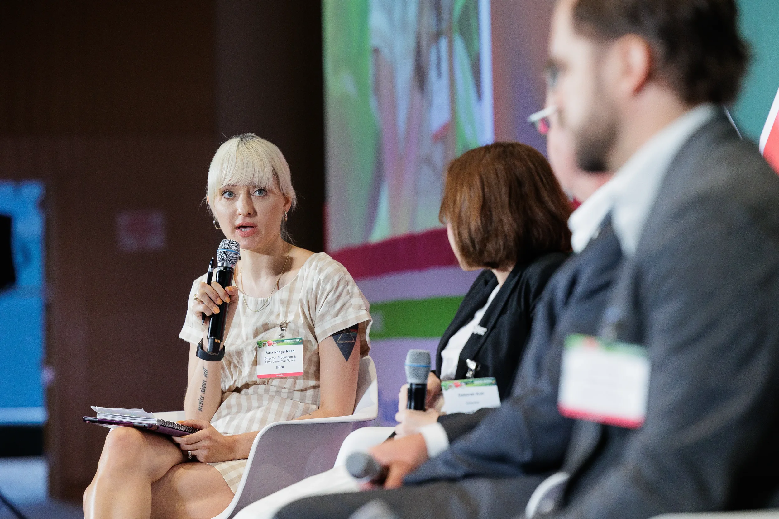 Panelist addresses fellow speakers during discussion on stage at Orlando corporate event