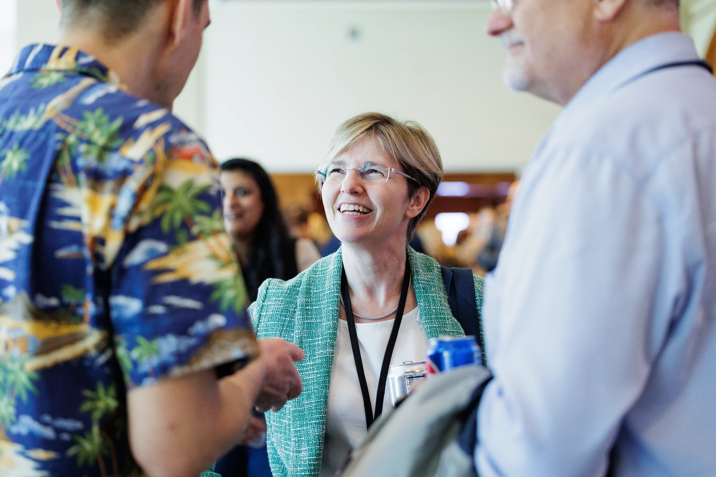 Attendee smiles during conversation with colleagues at Orlando industry conference