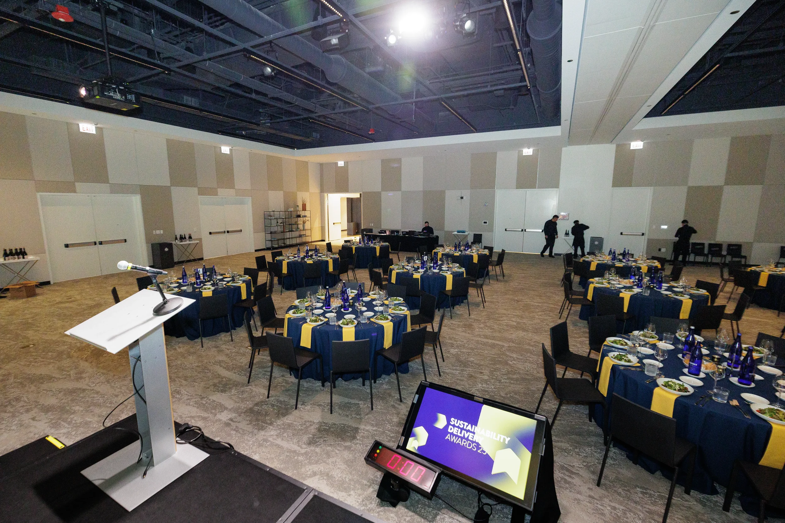 Empty ballroom set with dinner tables and podium ahead of Orlando corporate conference banquet