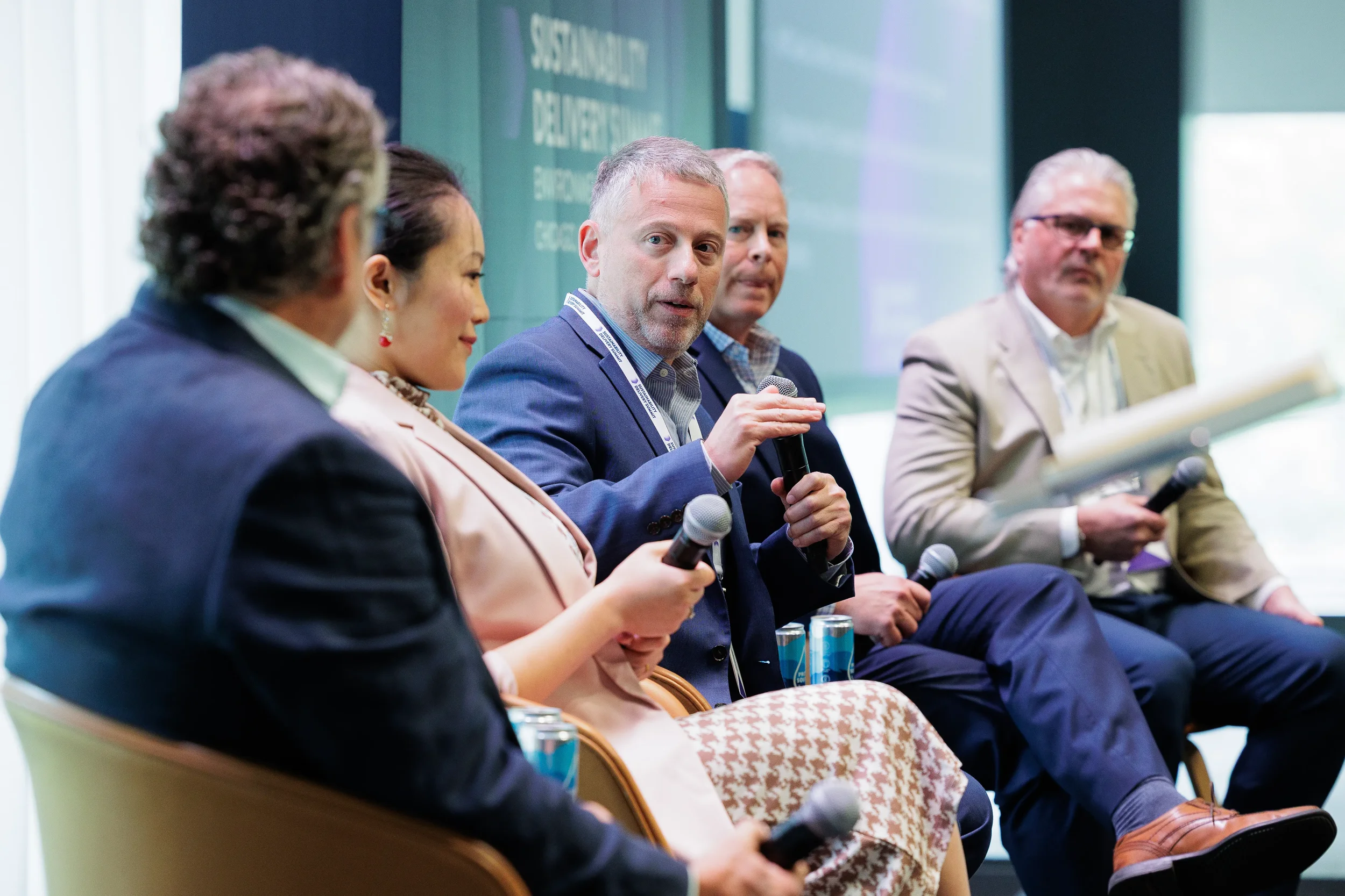 Panelists holding microphones engage in discussion in front of audience at Chicago industry conference