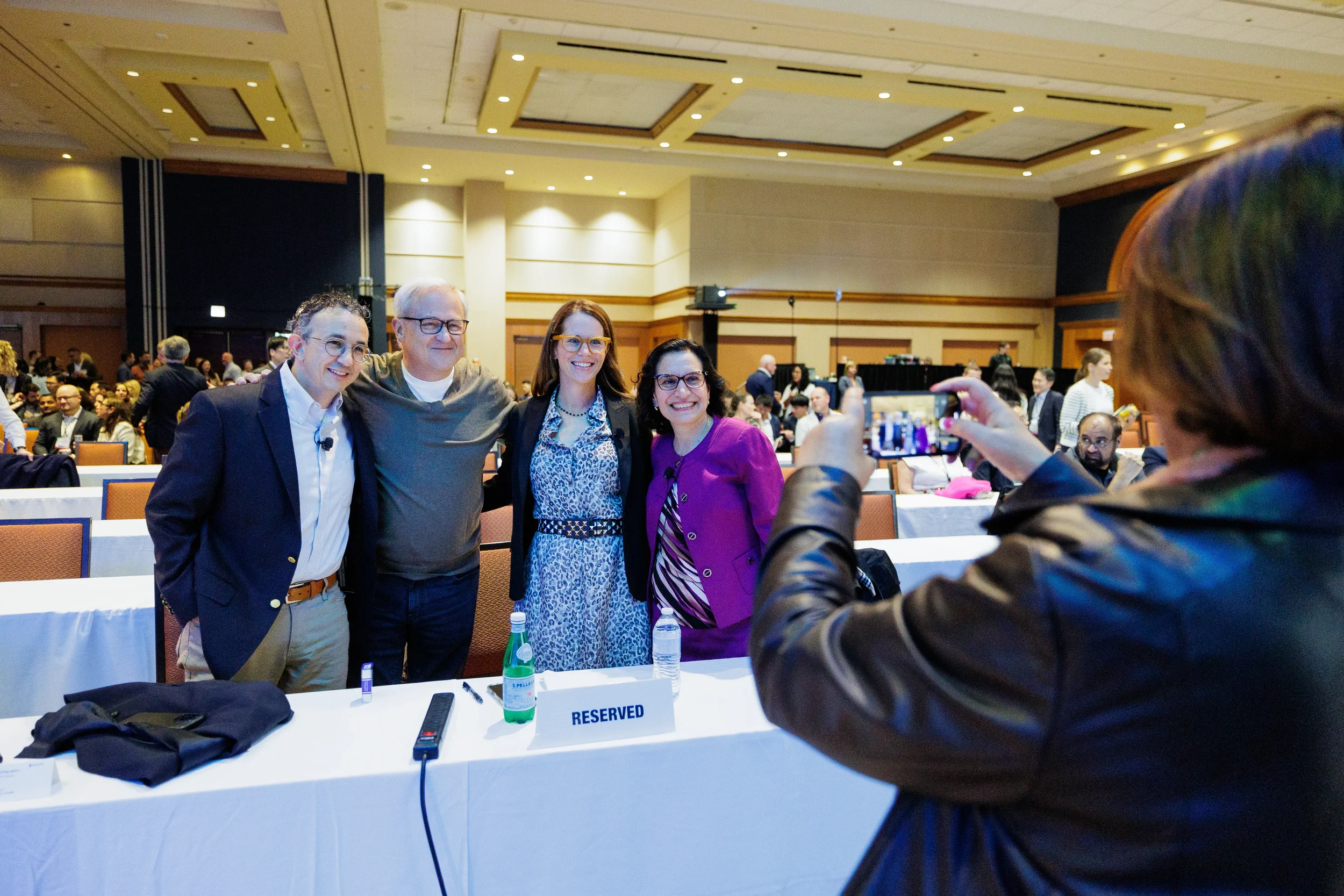 Group of attendees smile for photo in ballroom at Orlando corporate conference