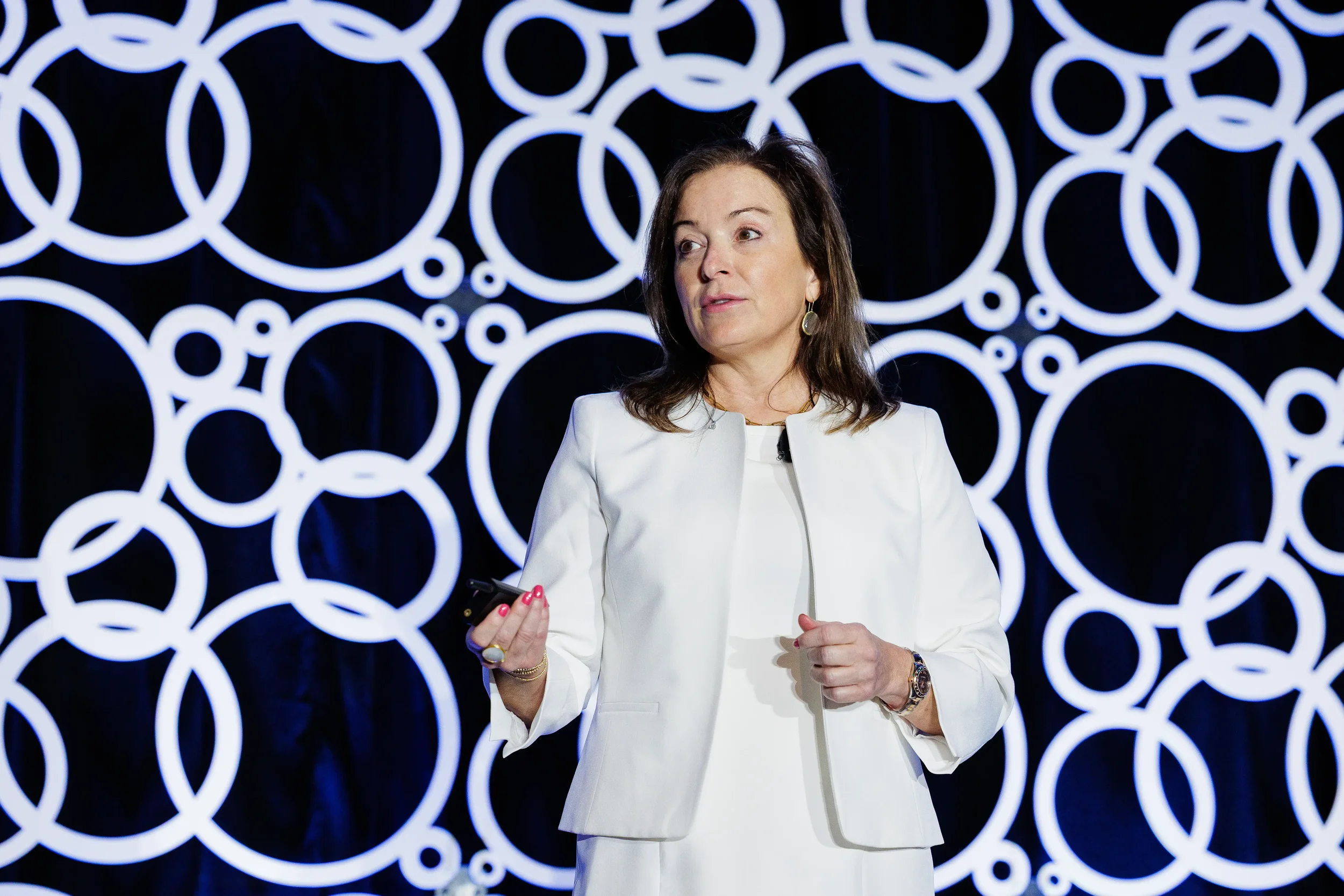 Speaker presents on stage with branded circle backdrop at Chicago industry conference