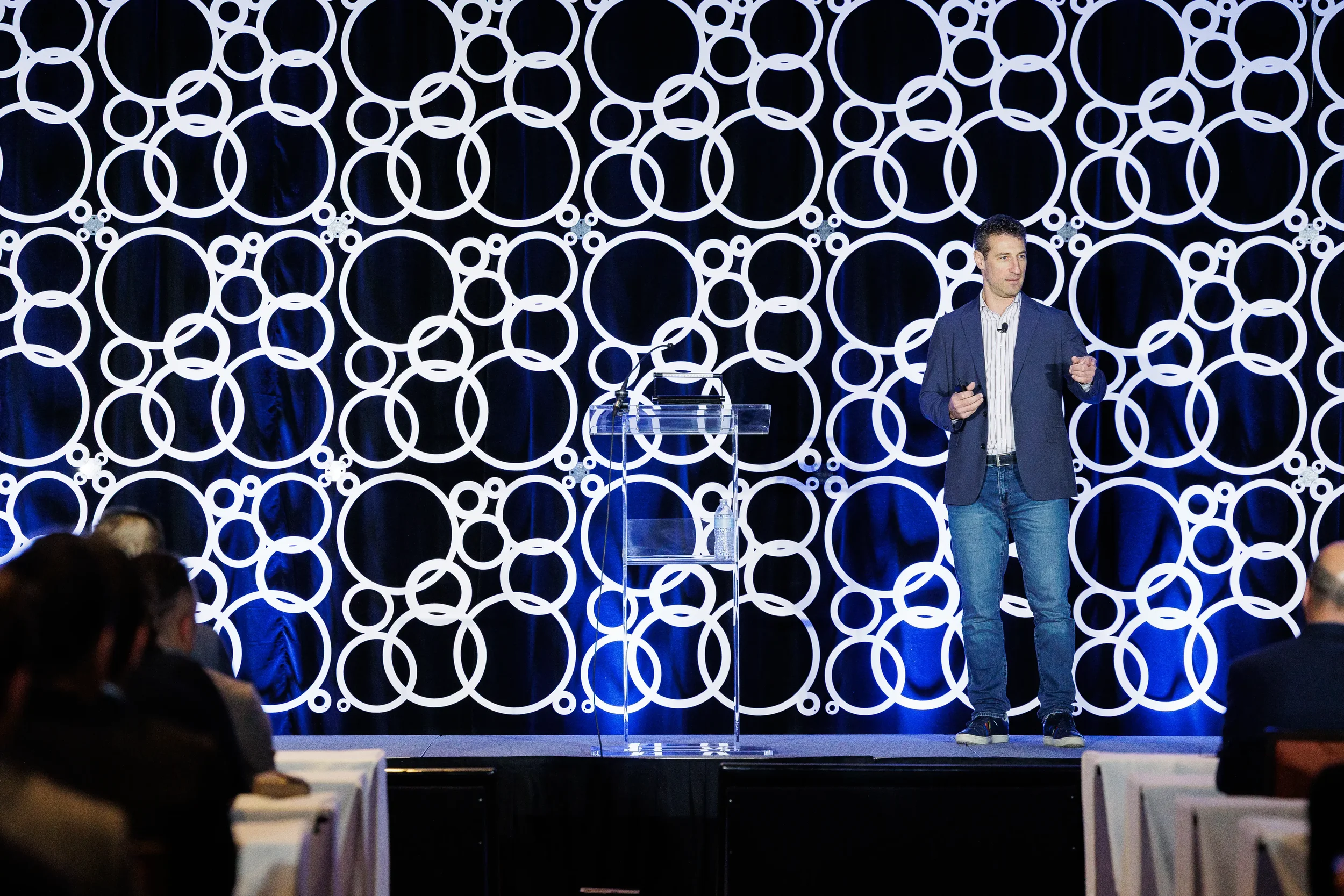 Speaker gestures while addressing audience on stage at Chicago corporate event