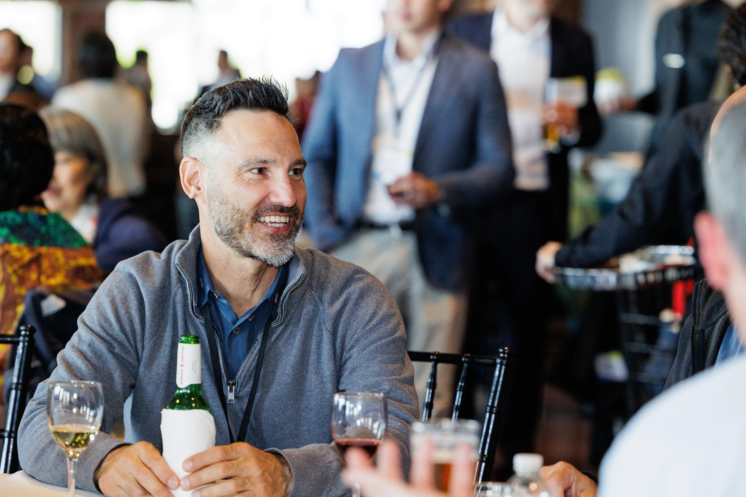 Attendee smiles while seated with drinks during Orlando corporate event reception
