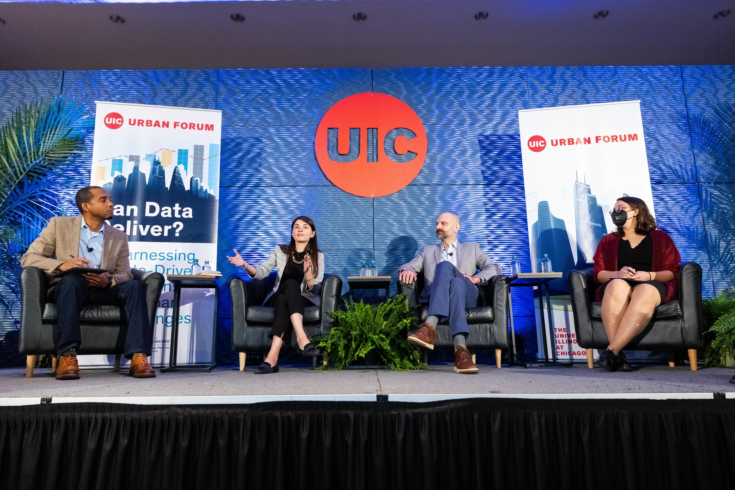 Four panelists discuss topics on branded stage during panel session at Orlando corporate event