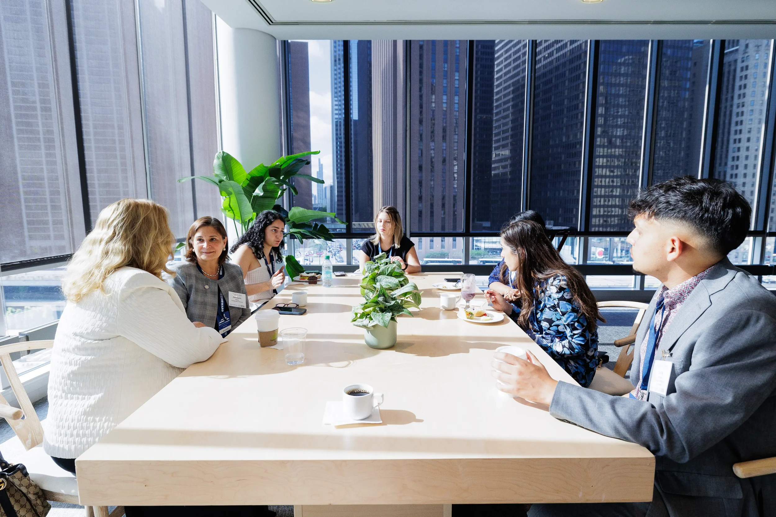 Attendees engage in discussion around table with city skyline views at Chicago corporate conference