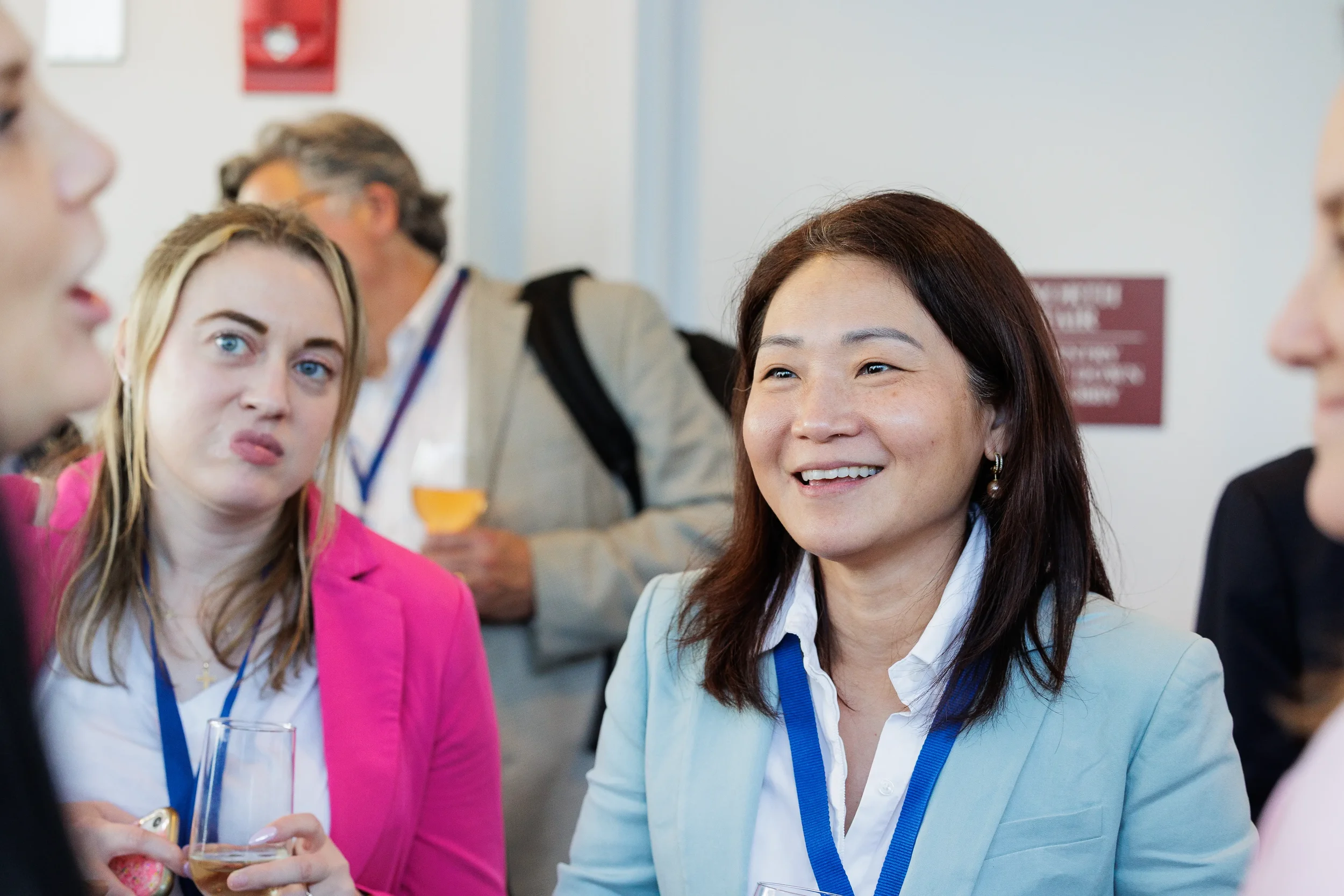 Attendees with lanyards laugh and network over drinks during Chicago industry conference reception
