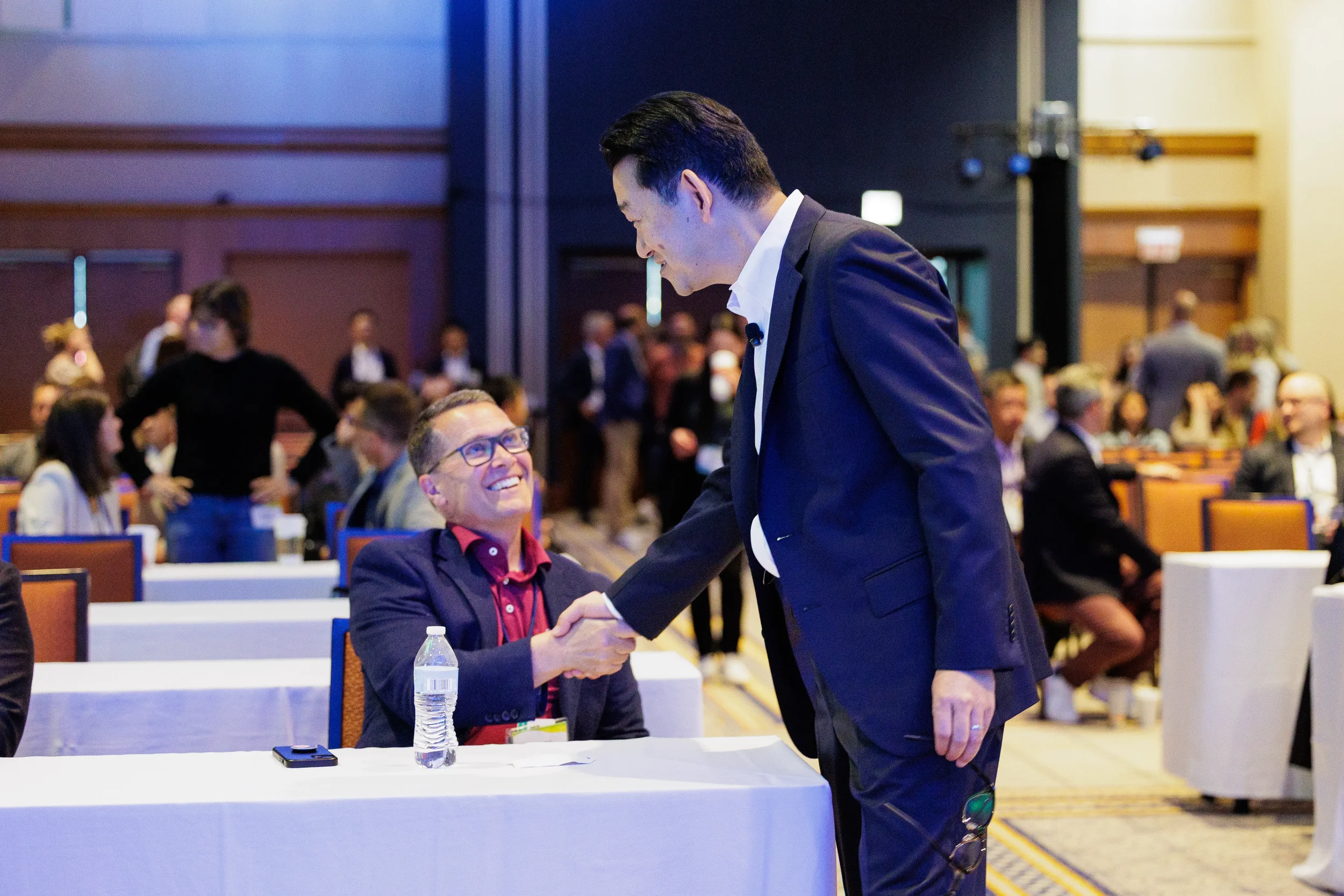 Two attendees shake hands and greet each other at Chicago industry conference