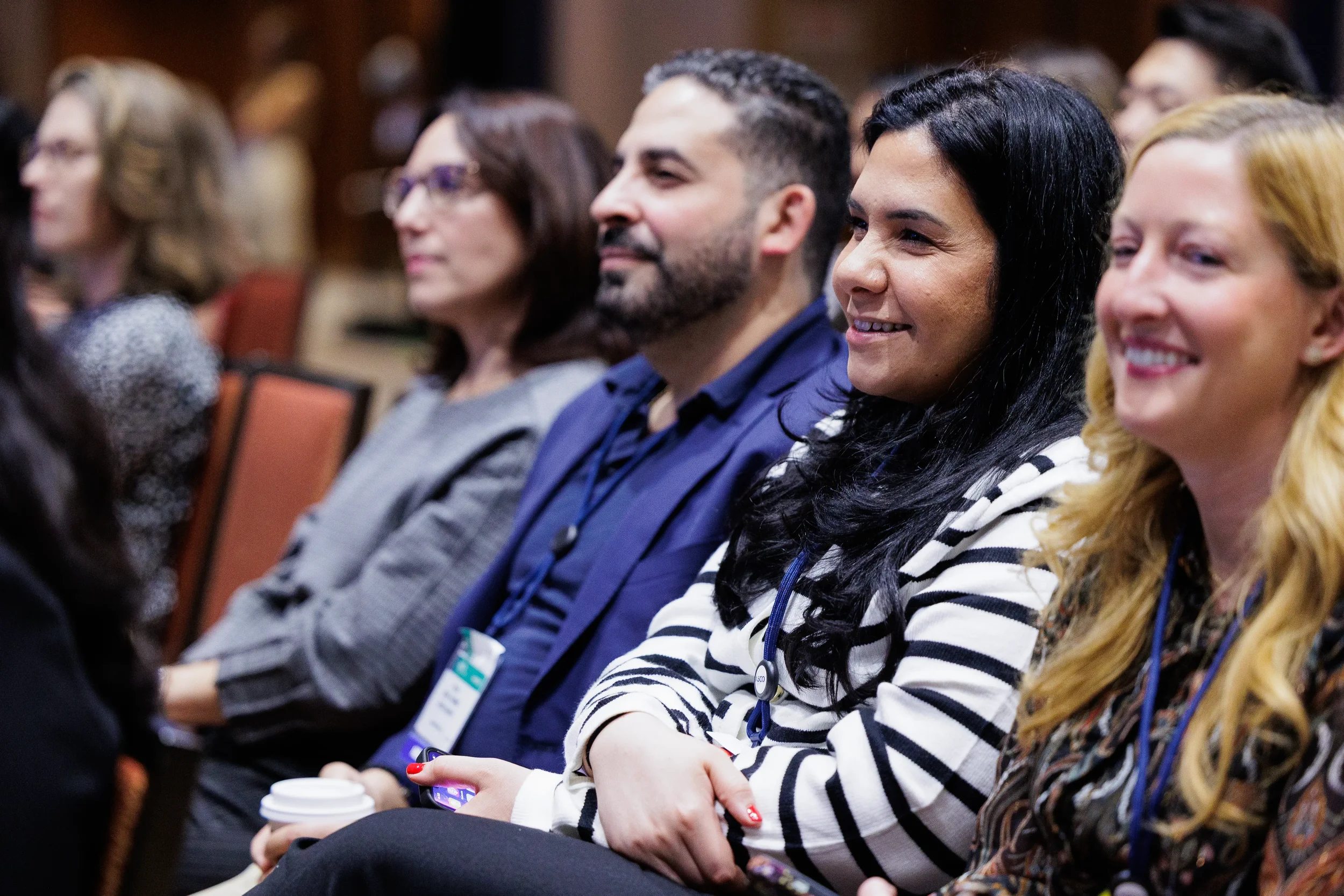Attendees smile while seated during general session at Chicago industry conference