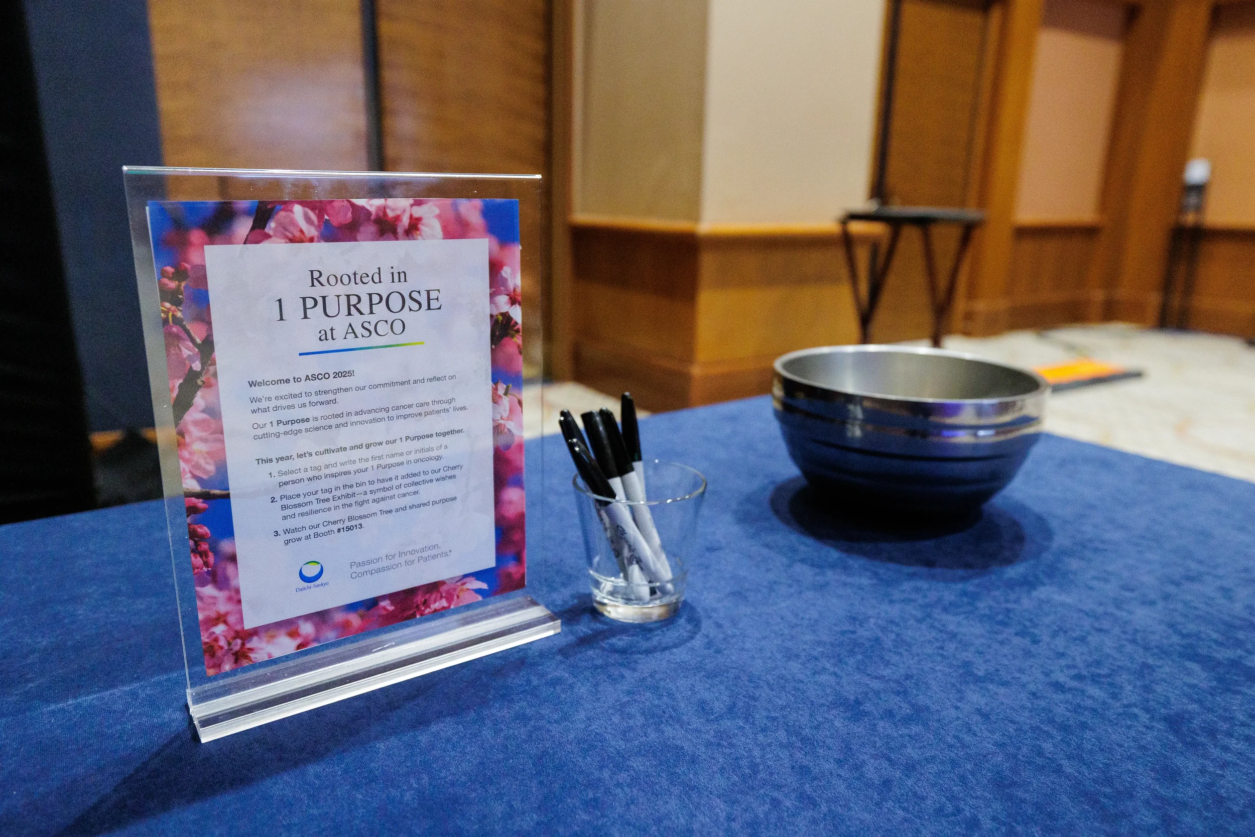 Cherry blossom sign, pens and bowl on blue-draped table at Chicago industry conference activation