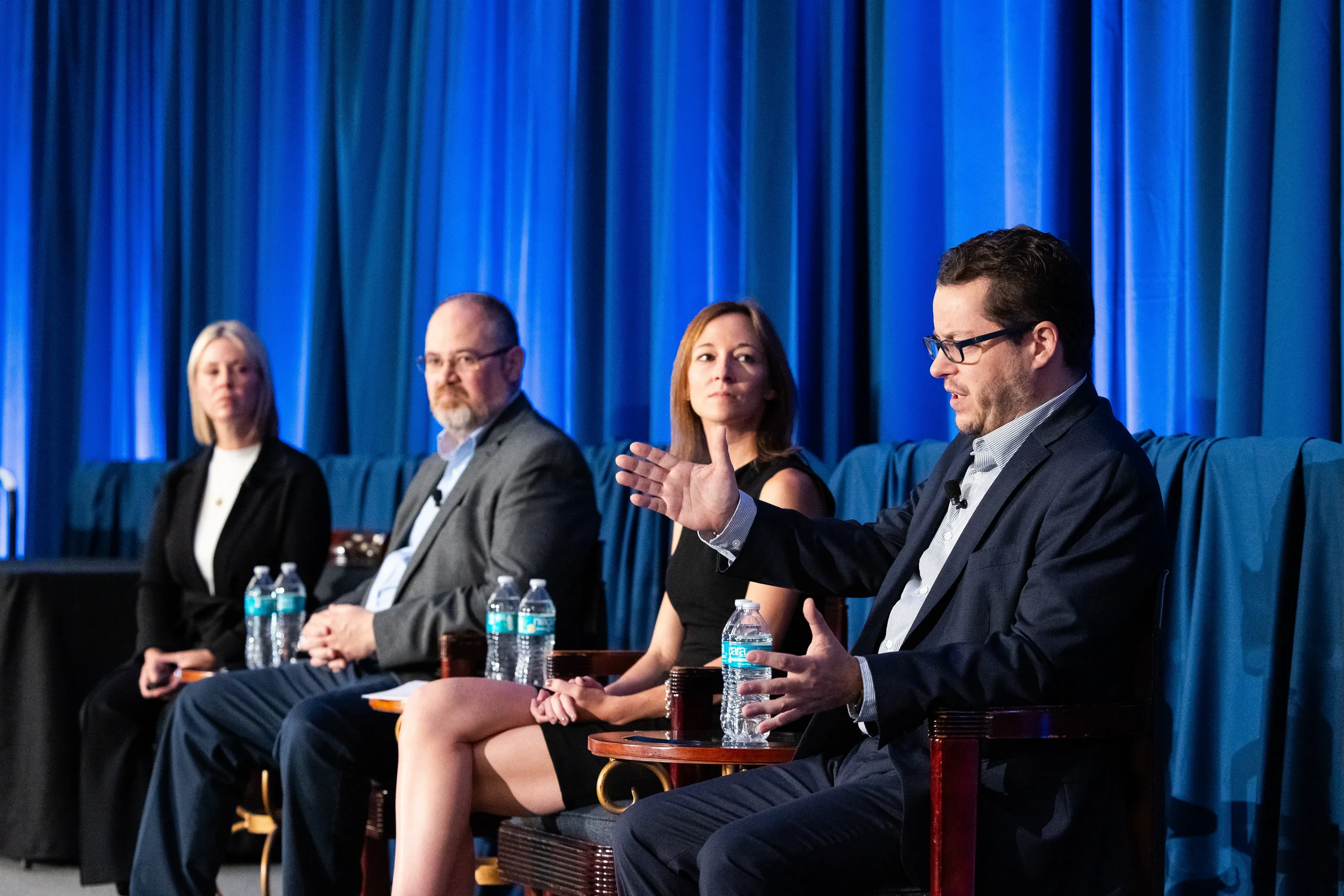 Panelist gestures while speaking during discussion on stage at Orlando industry conference
