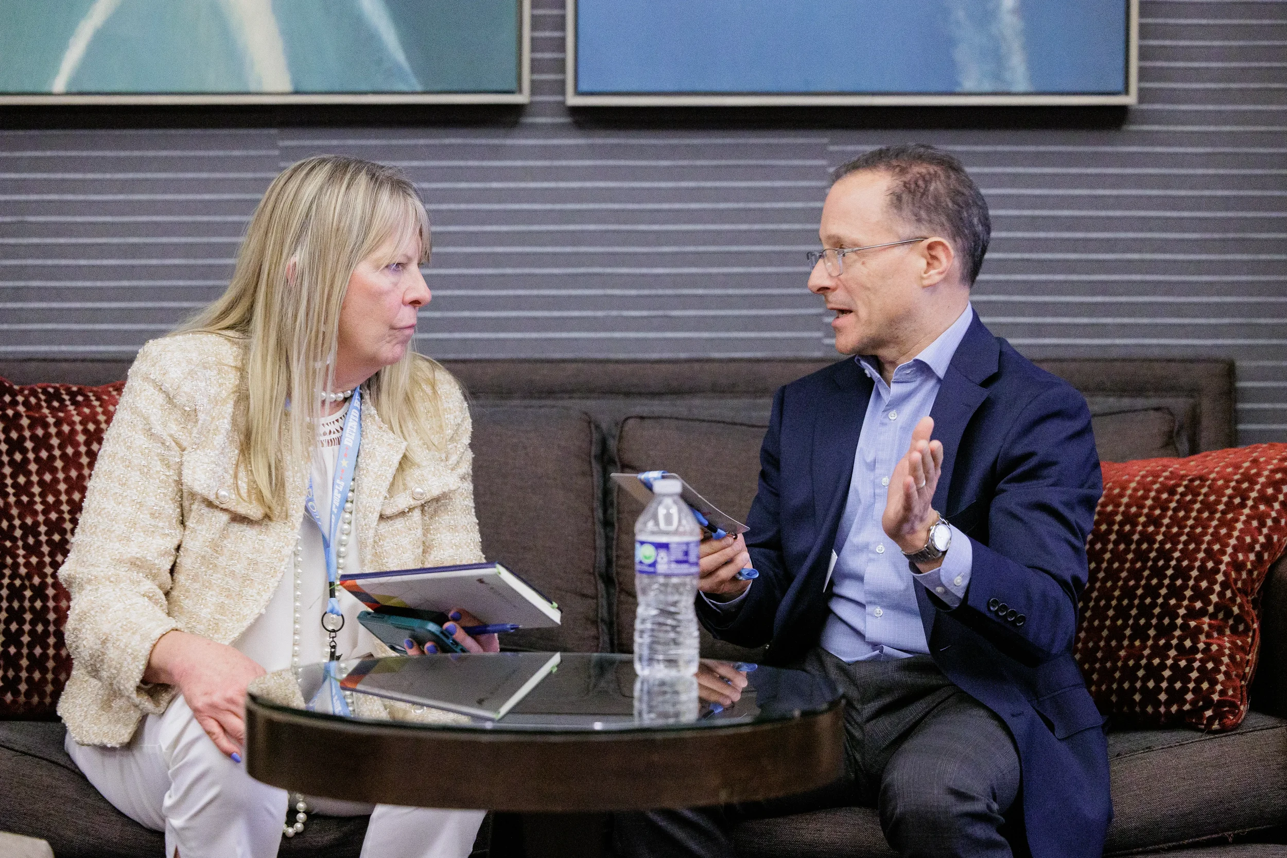 Two conference attendees discuss business in lounge area during Chicago corporate event